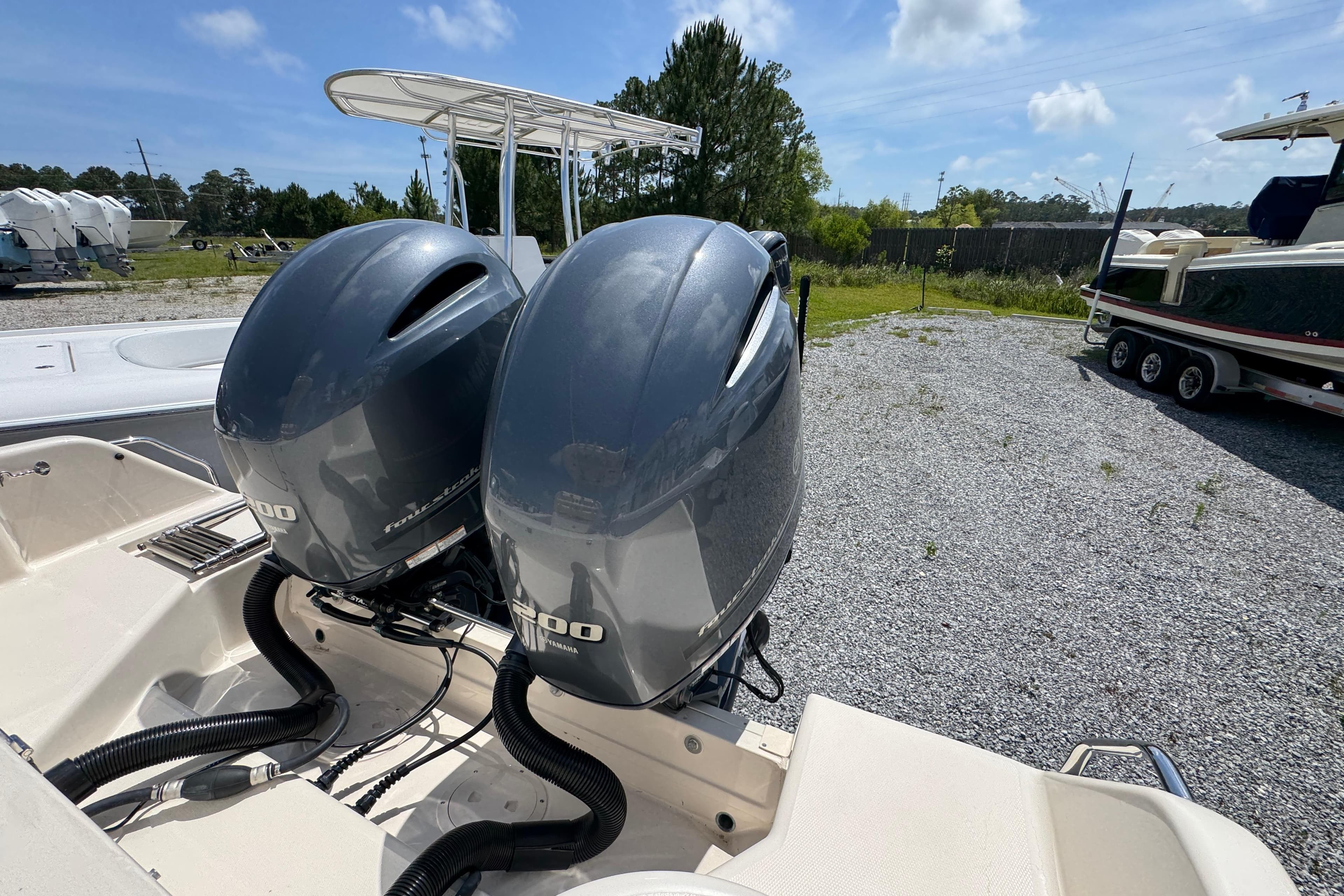 Twin outboard engines on a 2022 Grady-White Fisherman 257 boat, parked on gravel.