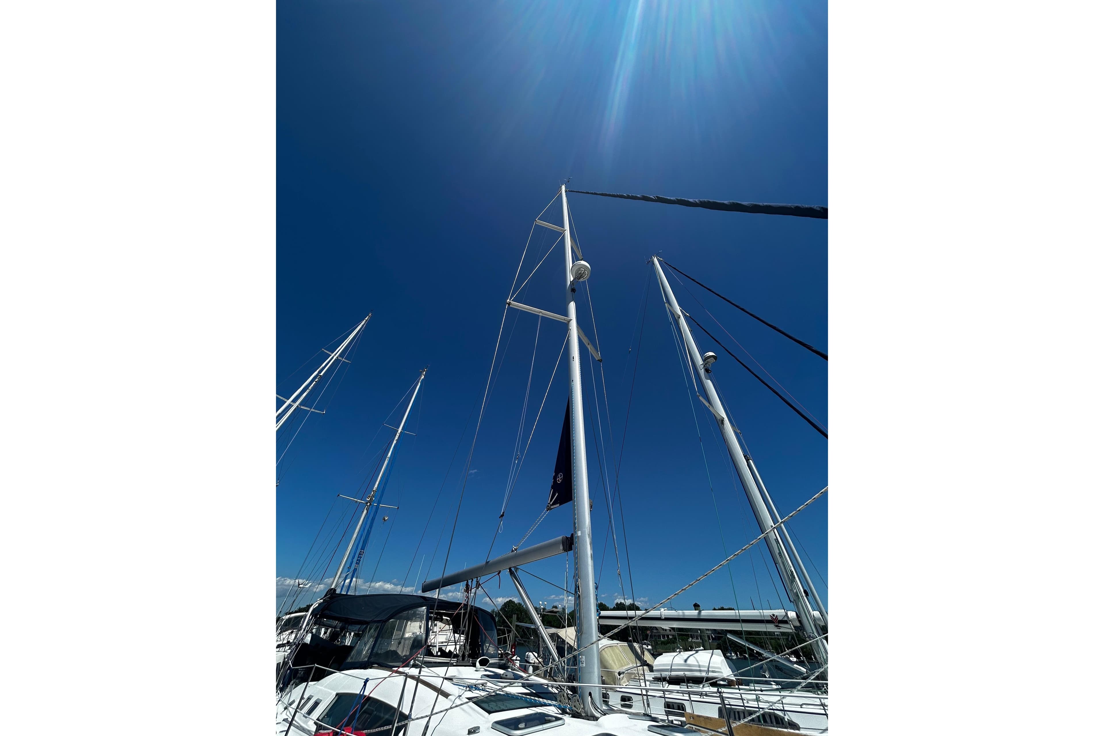 Masts of a 2008 Beneteau Oceanis 46 sailboat against a clear blue sky.