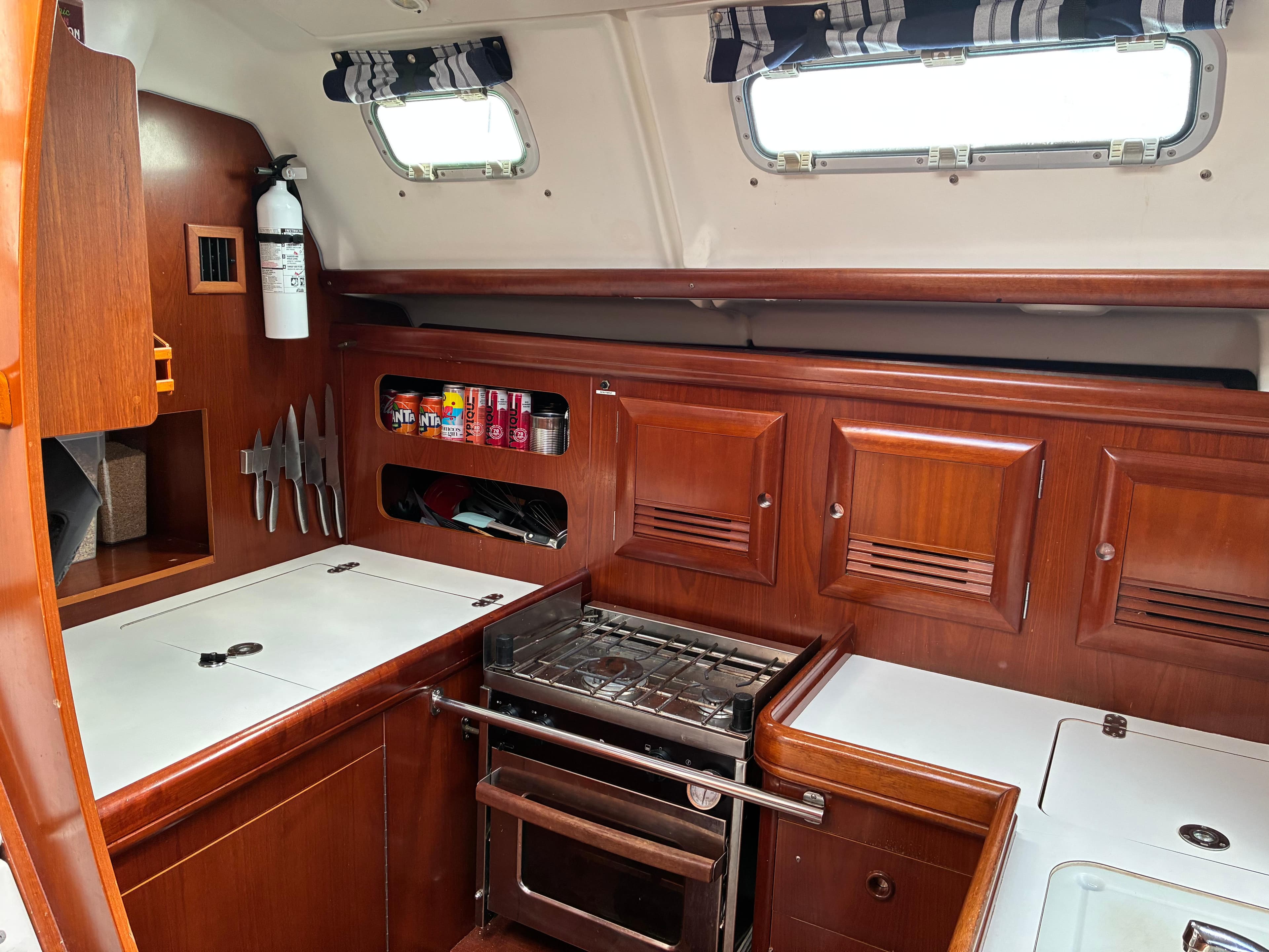 Galley of 2003 Beneteau Oceanis Clipper 393 with stove, storage, and wooden cabinetry.