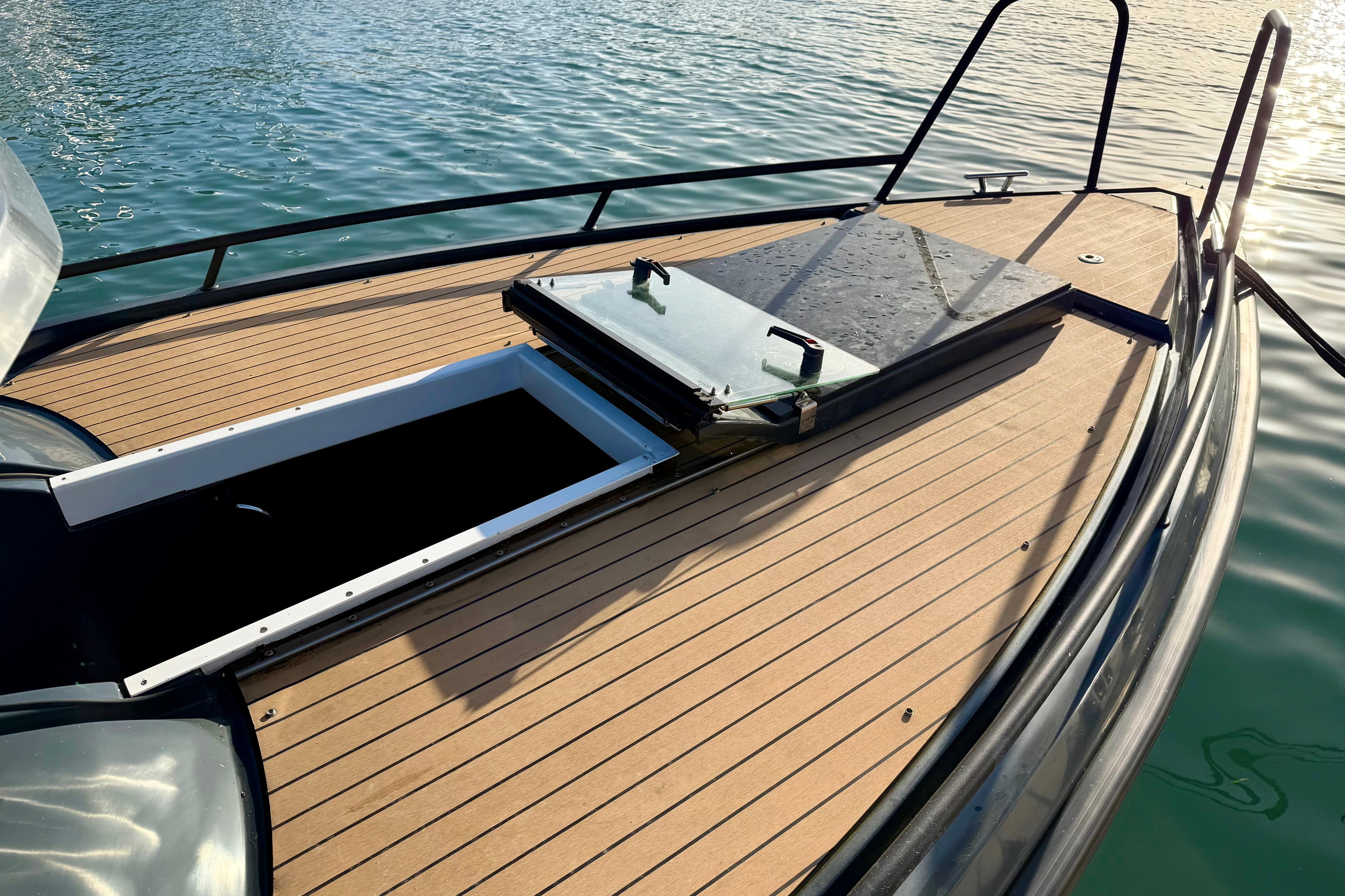 2022 XO EXPLR 10S boat deck with open hatch, on calm water.