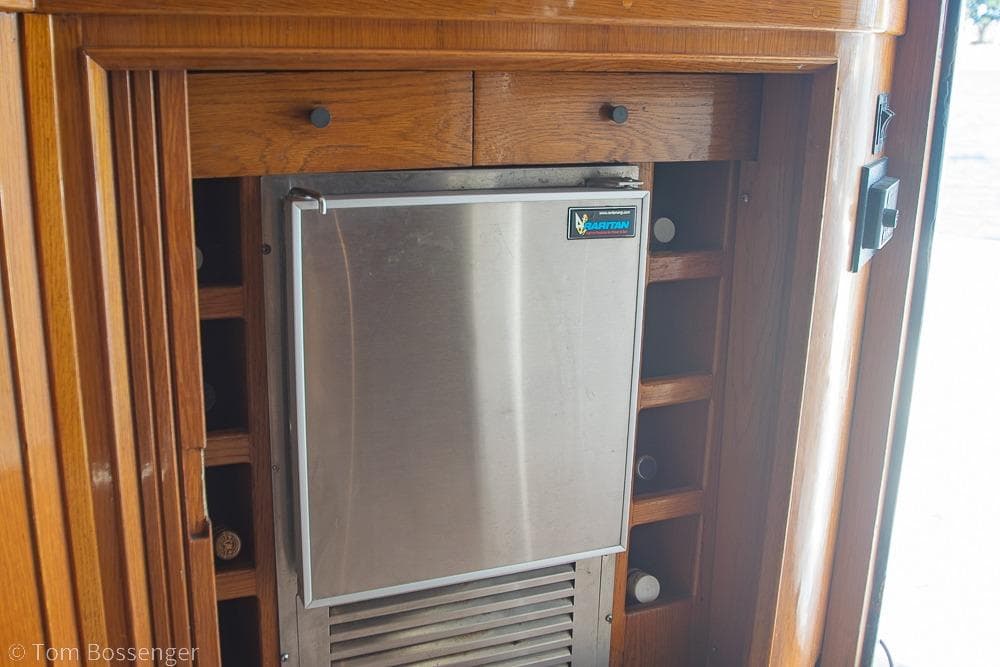 Built-in refrigerator on 1989 Bertram 50 Convertible yacht with wooden cabinetry.