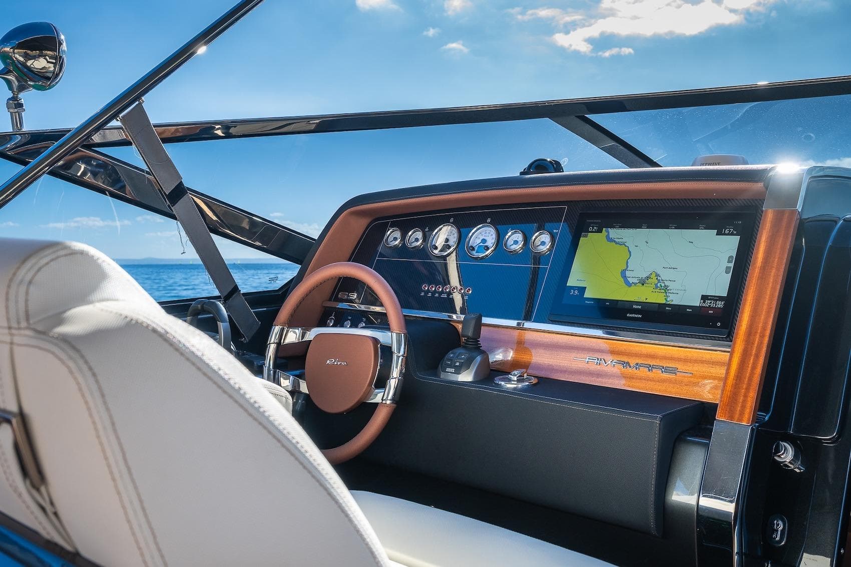 Cockpit of 2022 Riva 38 Rivamare yacht with navigation display and steering wheel.