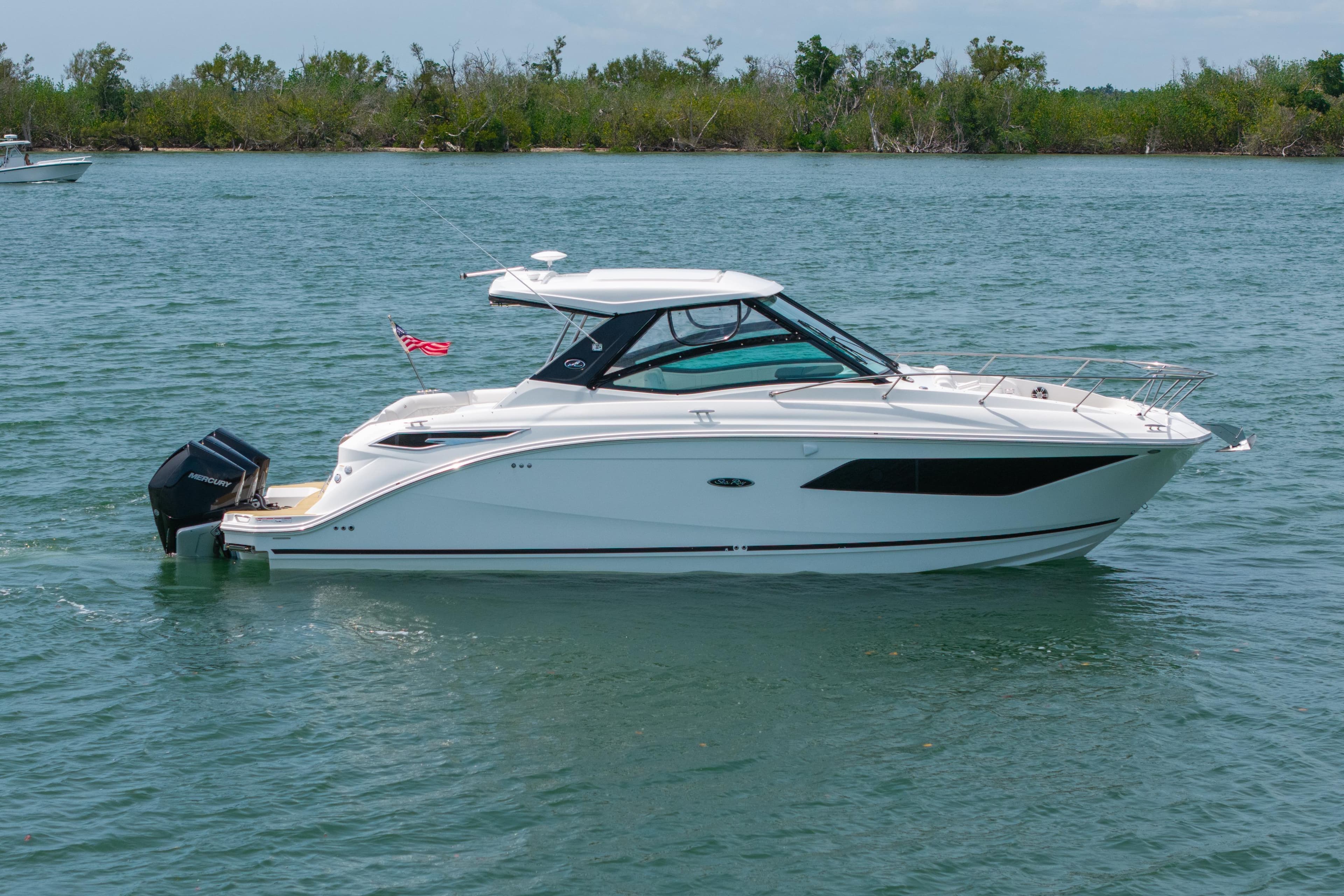 2024 Sea Ray Sundancer 320 Outboard cruising on a serene lake.