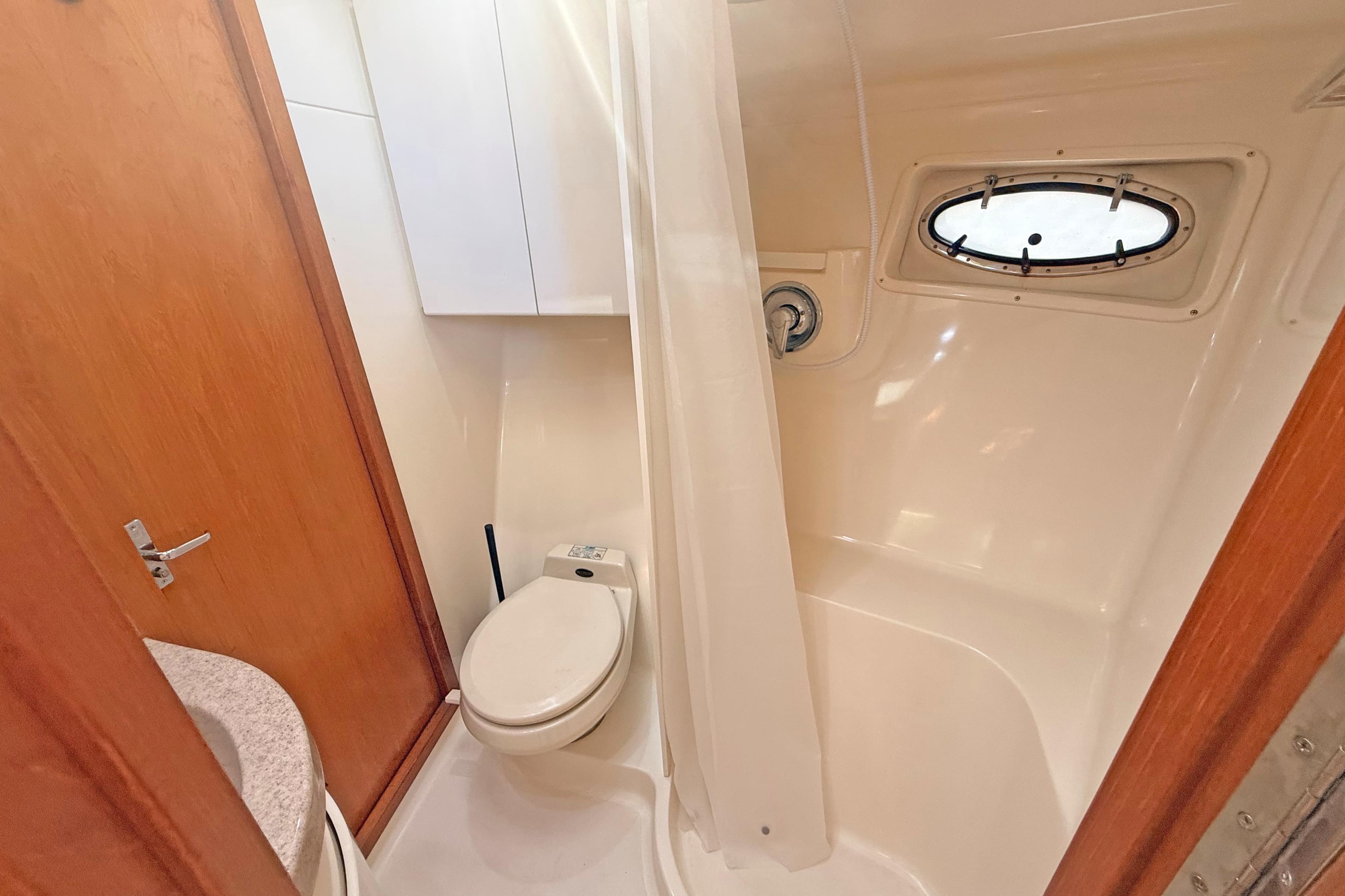 Bathroom interior of 1996 Tiara 3700 Open Hardtop yacht with shower and porthole.