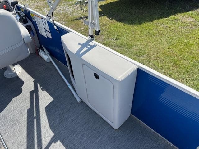 2022 Sweetwater 2286 boat interior with storage compartment and blue paneling.