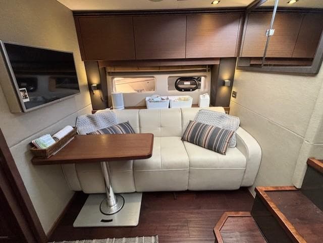 Luxurious interior of 2015 Sea Ray 470 Sundancer with sofa, table, and modern decor.