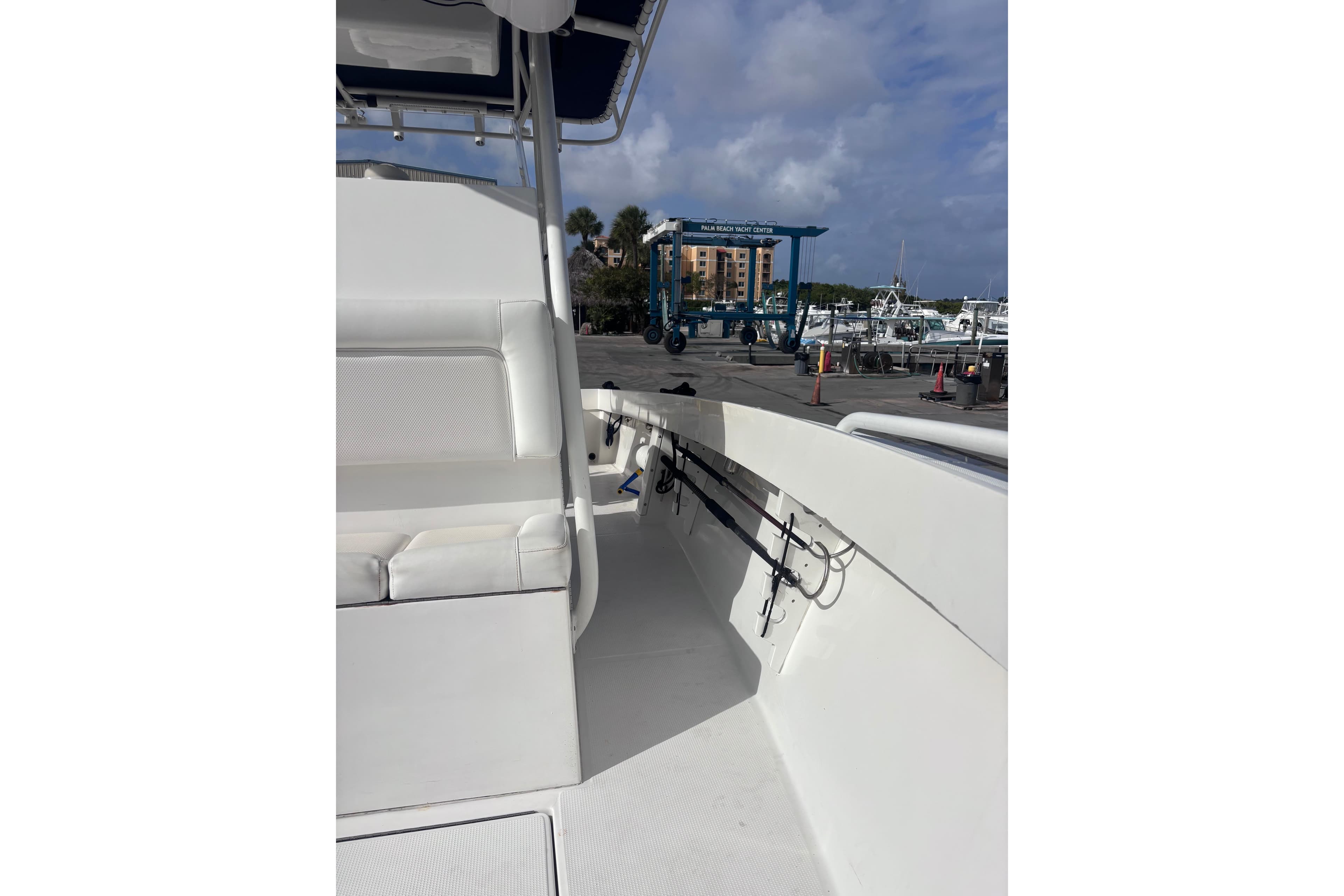 2003 Island Runner 26 Center Console boat interior at marina, featuring seating and rod holders.