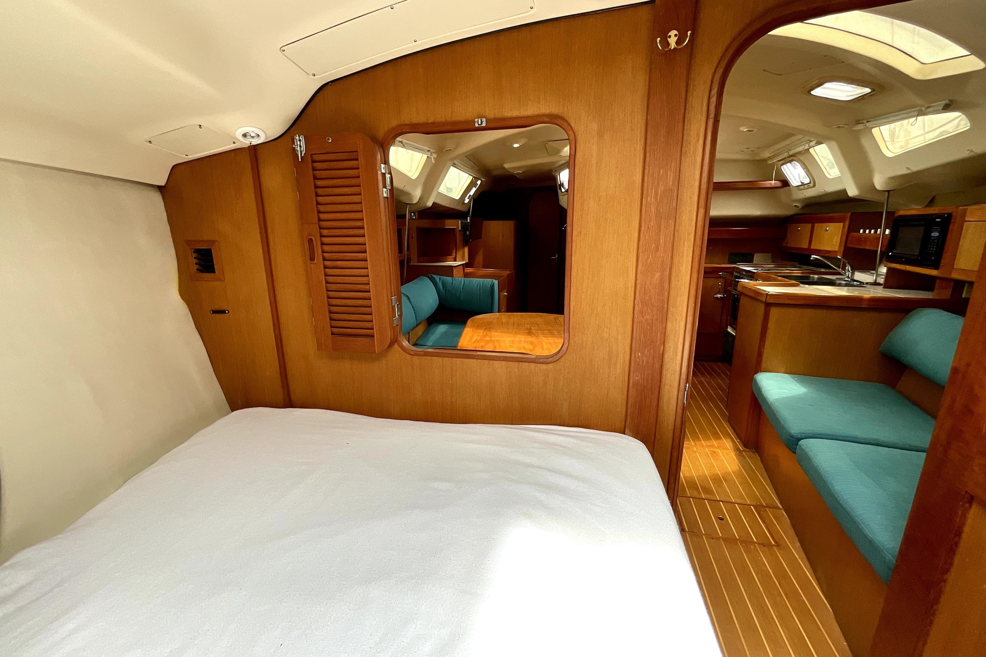 Interior of 1999 Hunter Passage 420 yacht with wood finish and teal seating.