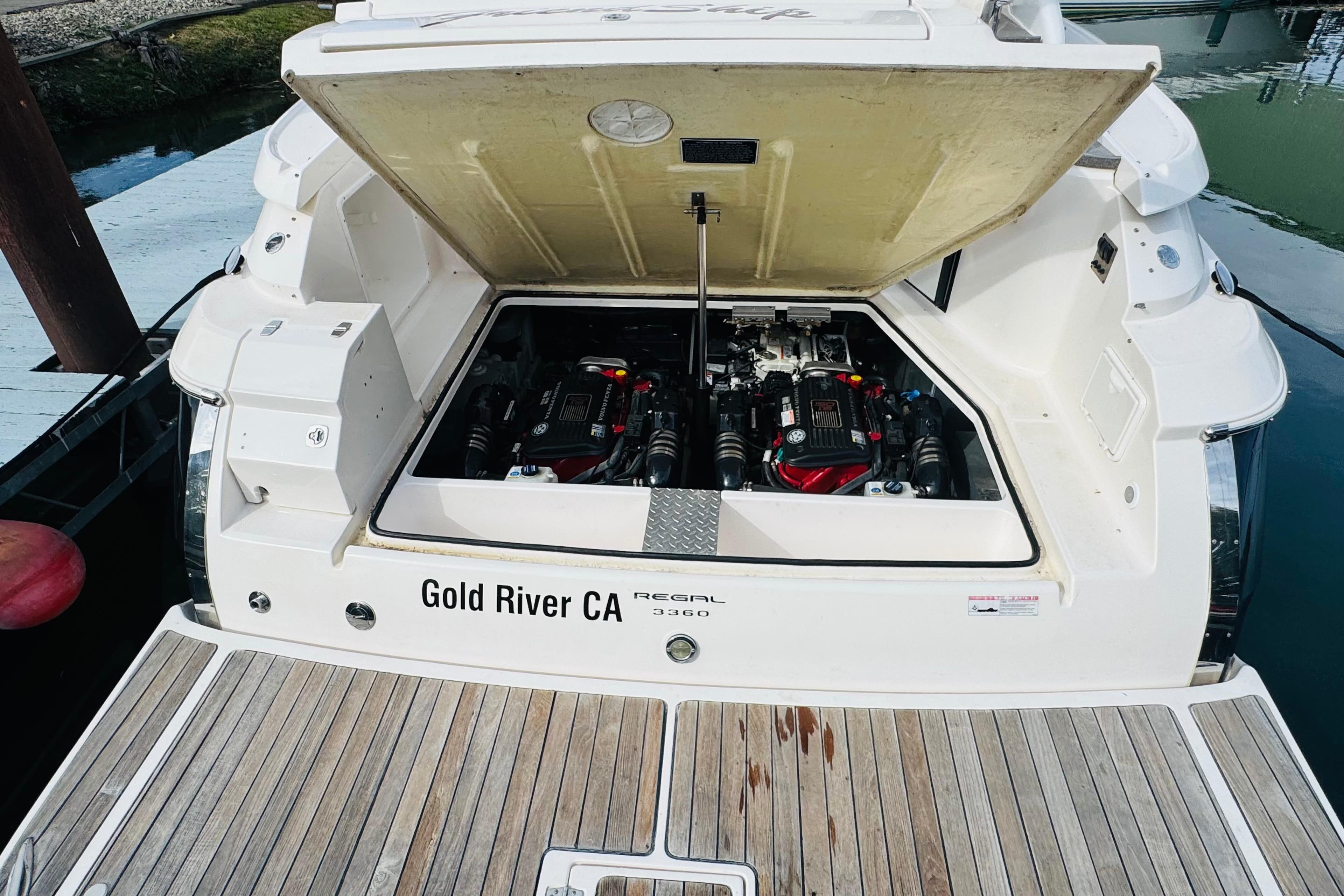 2006 Regal 3360 Window Express boat engine compartment open at dock.