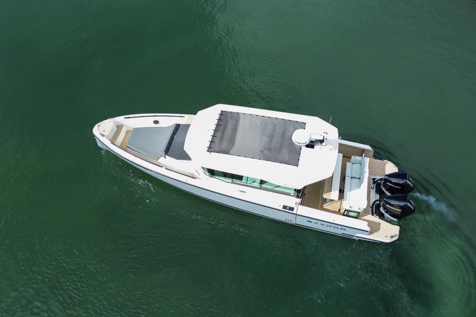 Aerial view of 2026 Saxdor 320 GTC boat cruising on calm water.