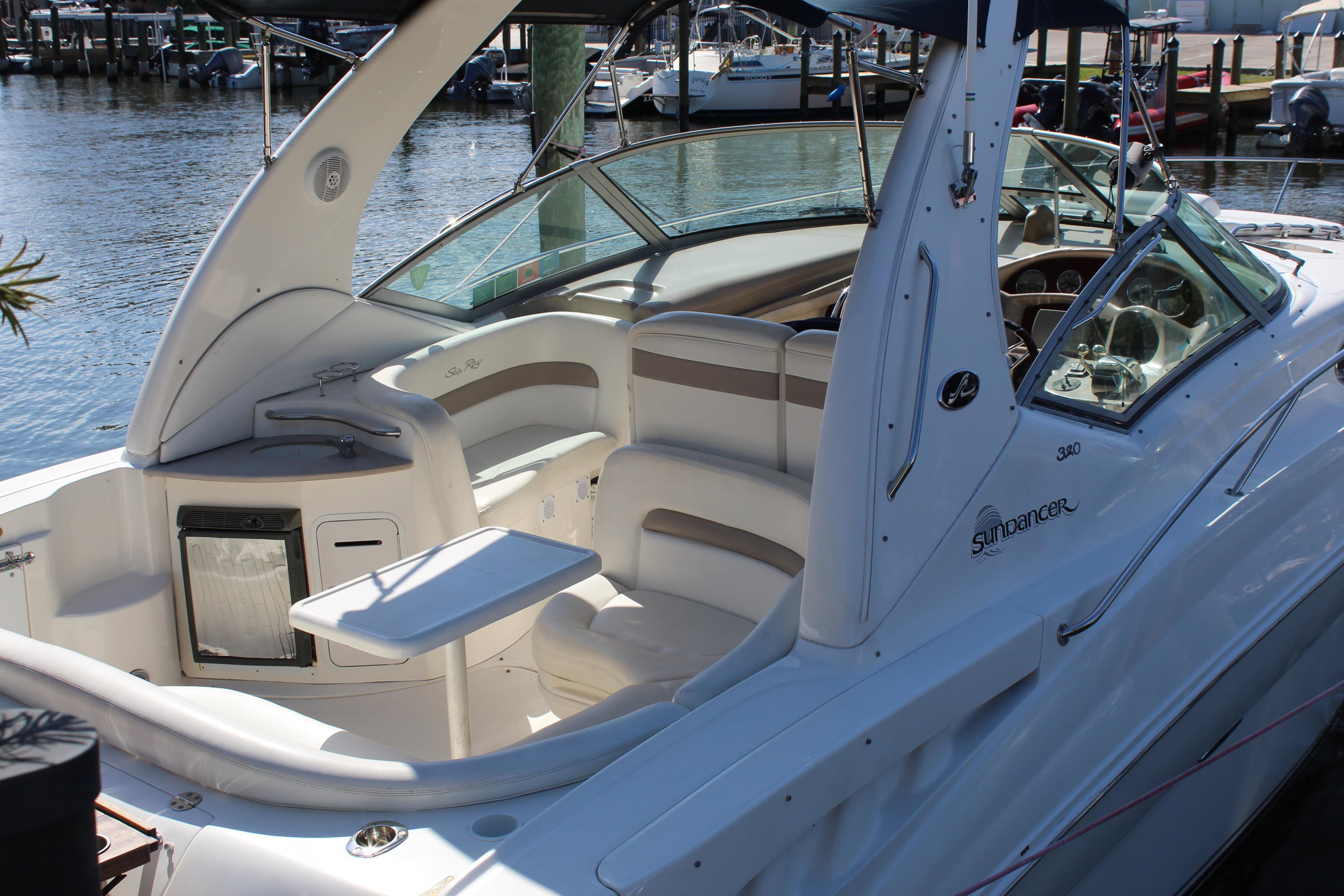 2005 Sea Ray Sundancer 320 boat interior with seating and table, docked at marina.