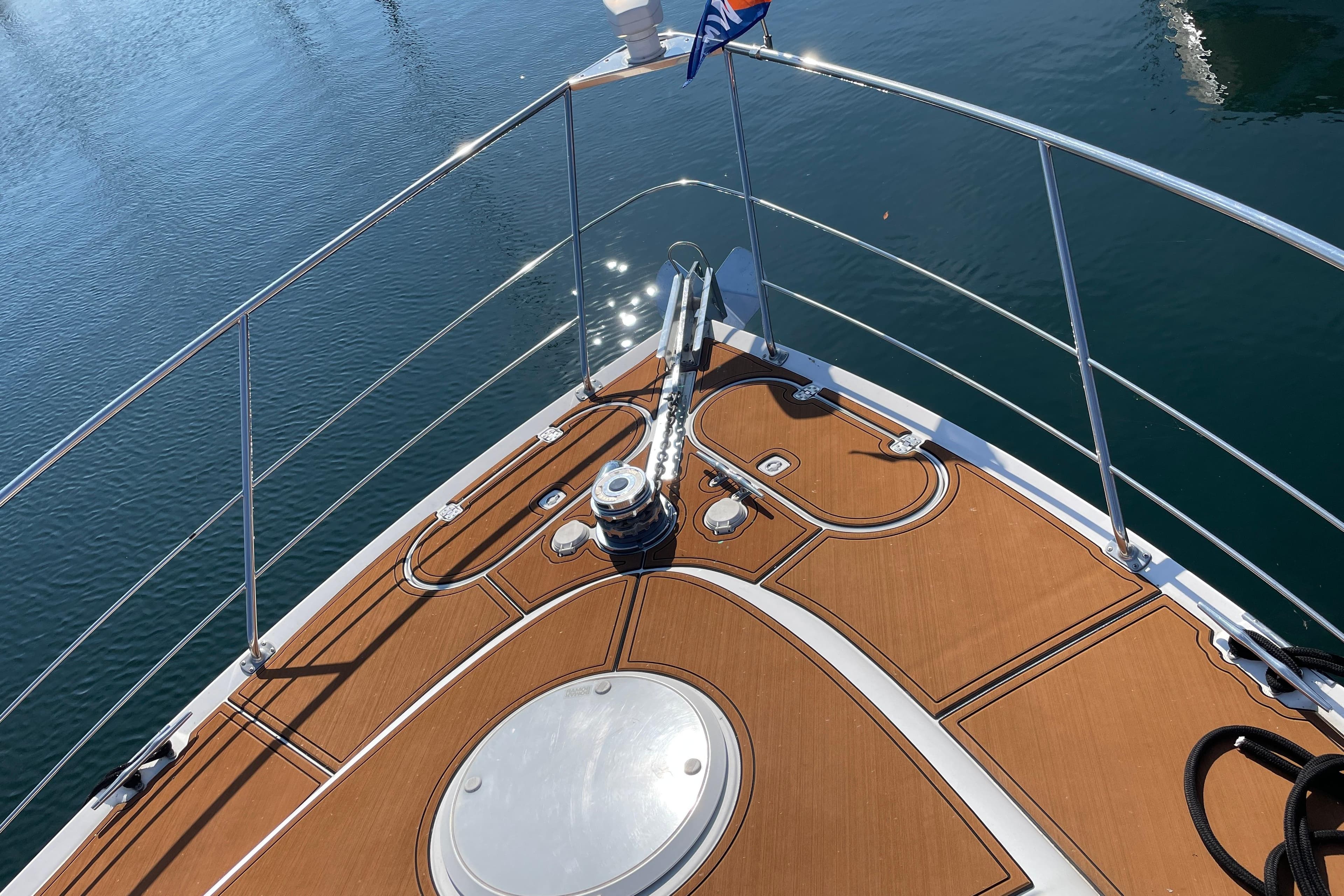 Bow of 2002 Carver 570 Voyager Pilothouse with teak deck and stainless steel railings.