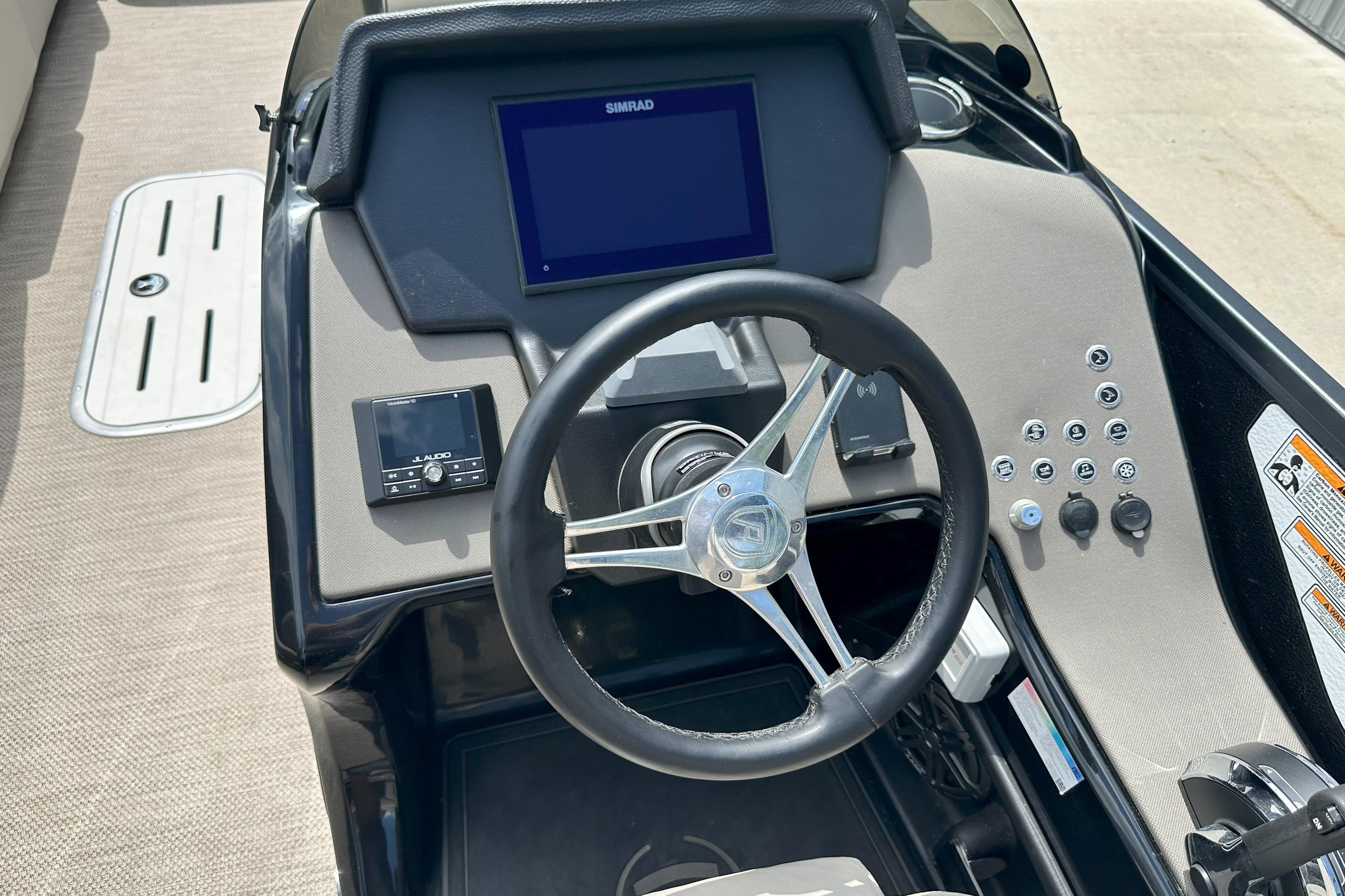 Steering console of 2021 Premier 250 Solaris RE boat with Simrad display and controls.