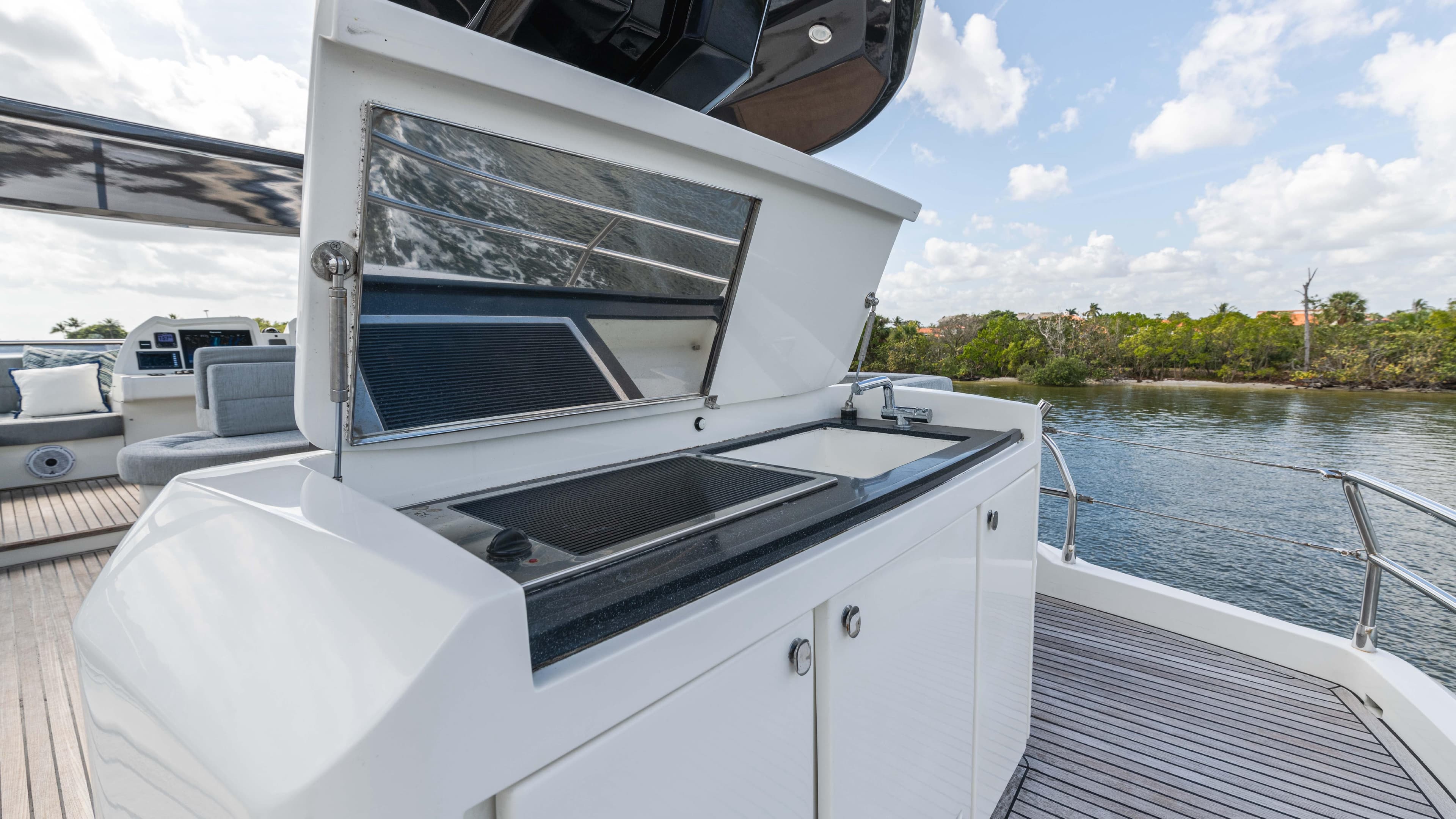 Outdoor kitchen on 2016 Monte Carlo Yachts MCY 65, featuring sleek design and scenic water view.