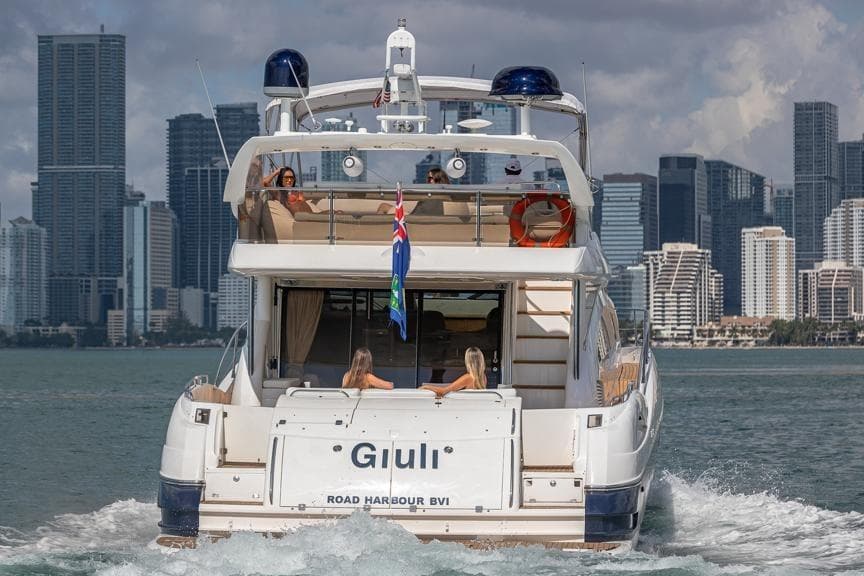 Sunseeker Manhattan 74 yacht cruising near city skyline, 2000 model.