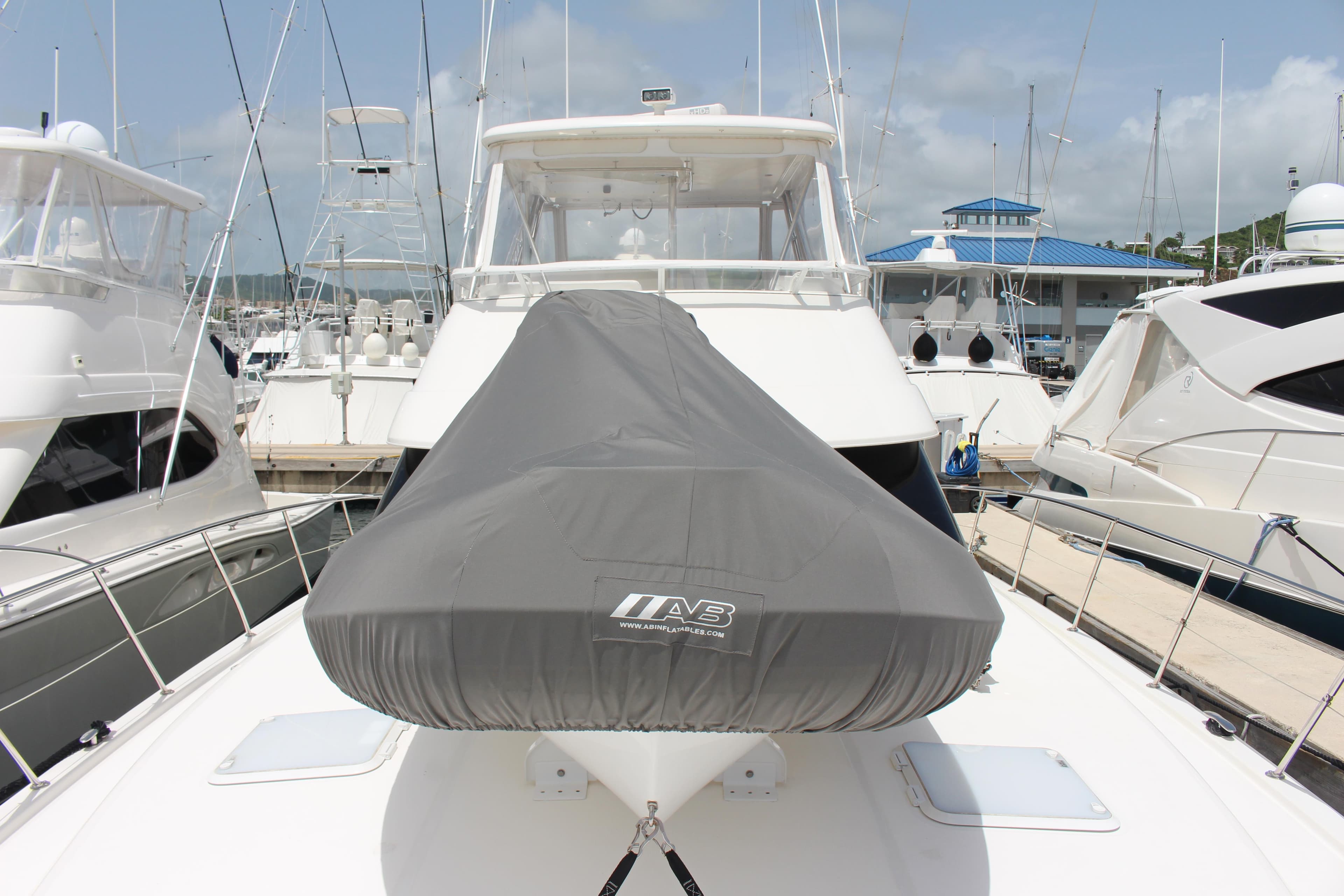 2005 Riviera 51 Flybridge yacht docked at marina, bow view with covered equipment.