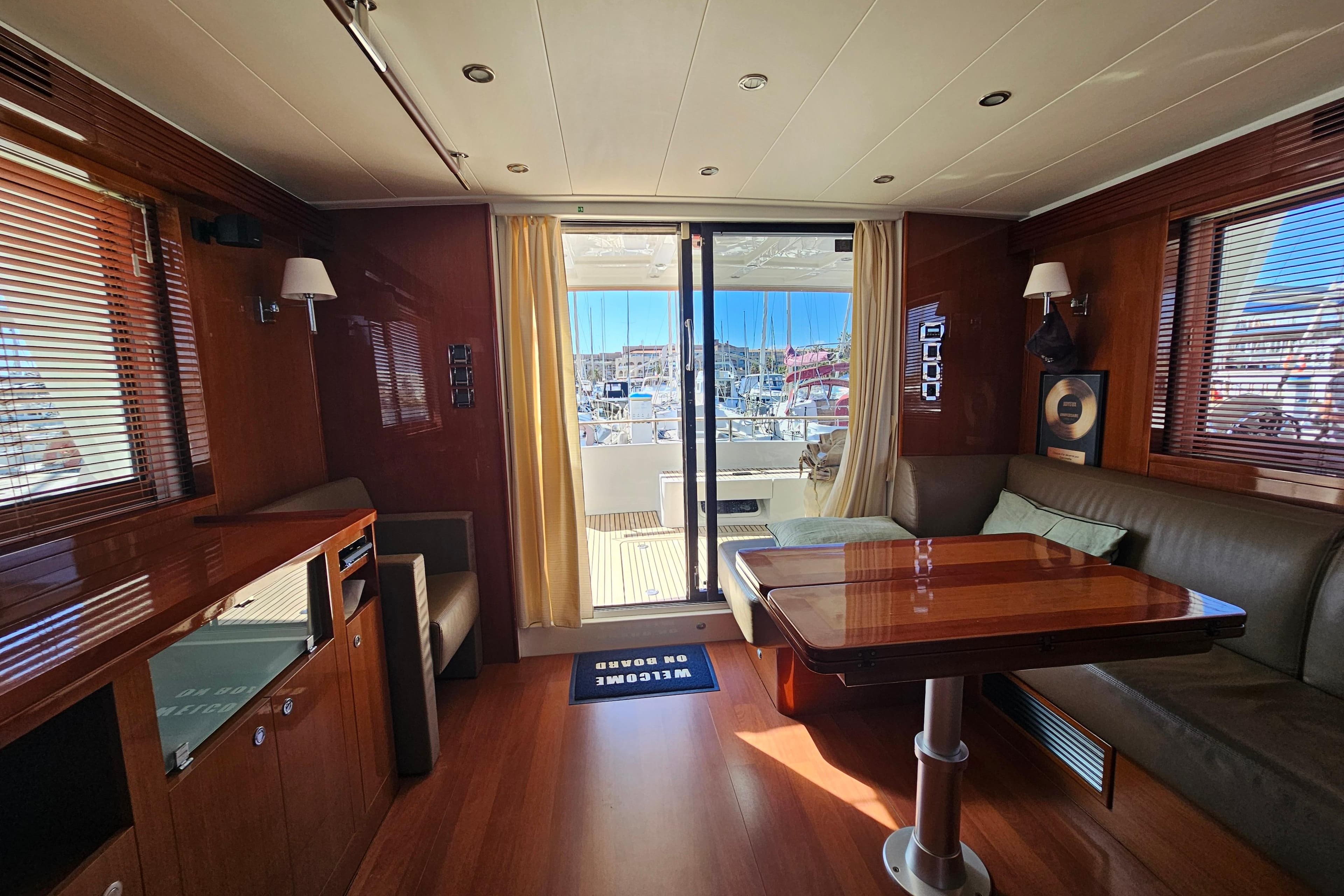 Luxurious interior of 2011 Beneteau Swift Trawler 52 with elegant wood finishes and marina view.