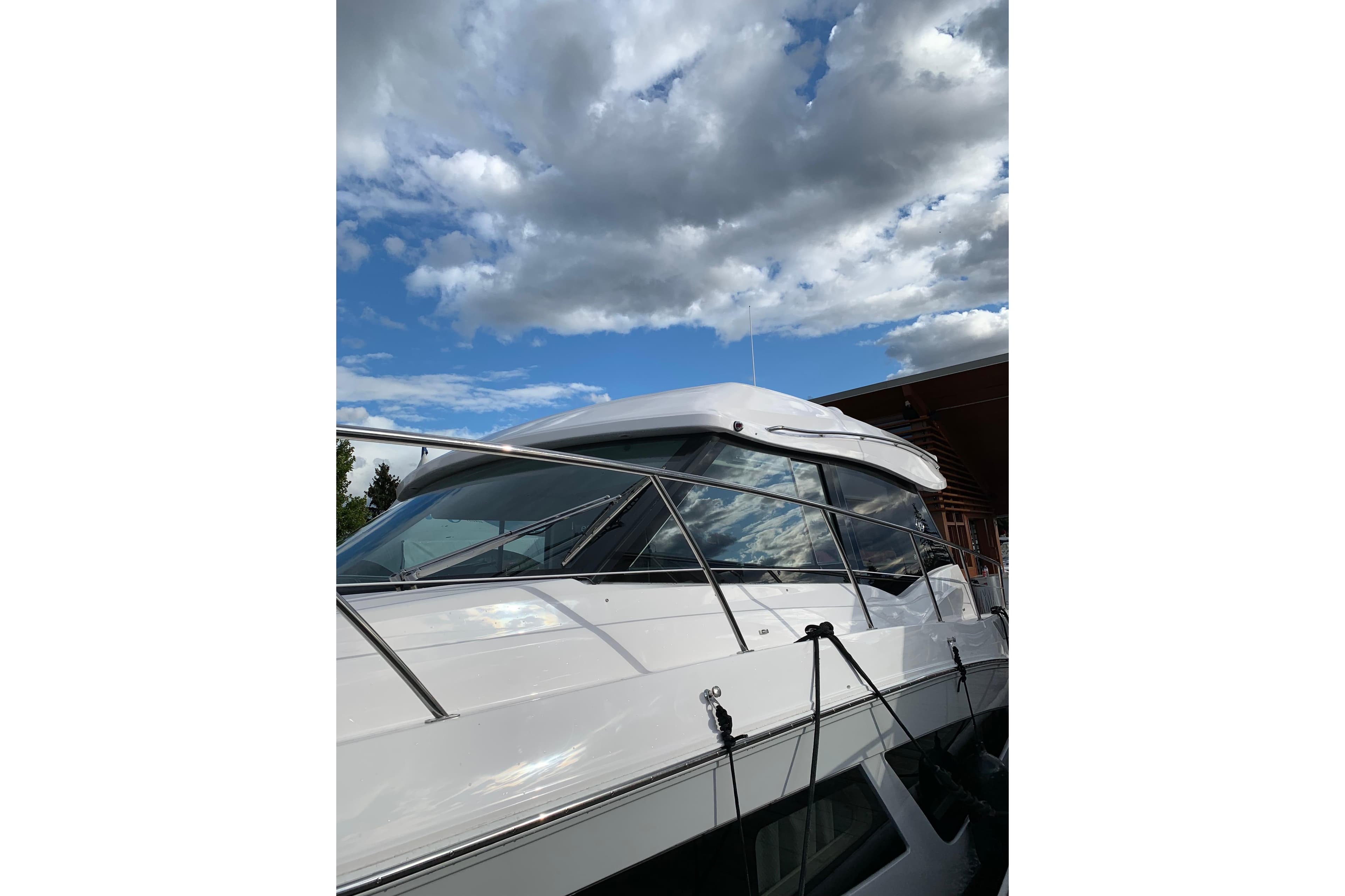 2019 Regal 42 Grande Coupe yacht under a partly cloudy sky.