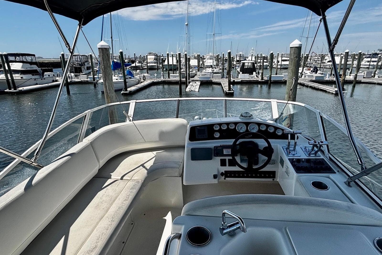 2001 Silverton 330 Sport Bridge yacht interior at marina, showcasing helm and seating area.