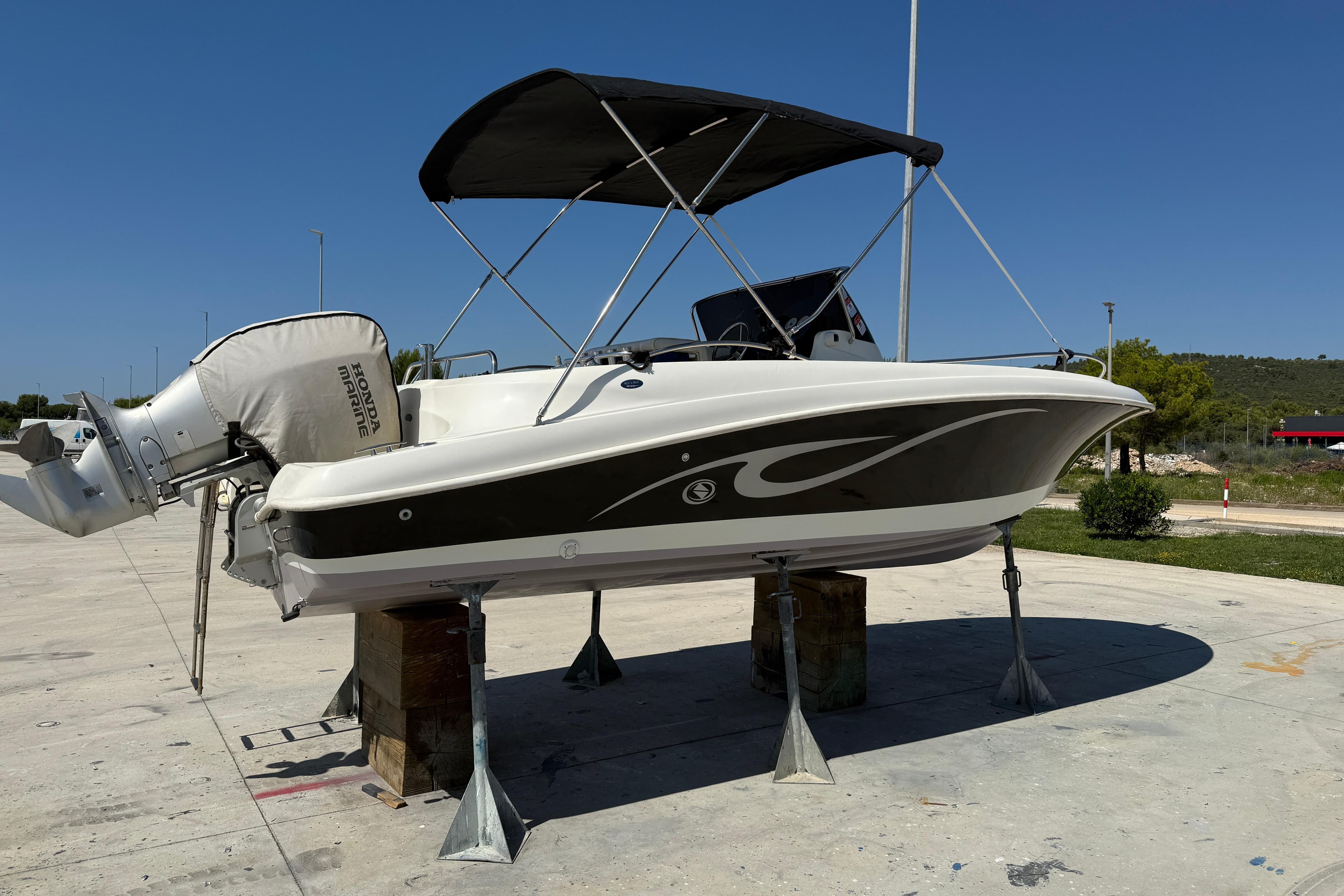 2008 Ocean Craft 640 WA boat with Honda Marine engine on stands, sunny day.