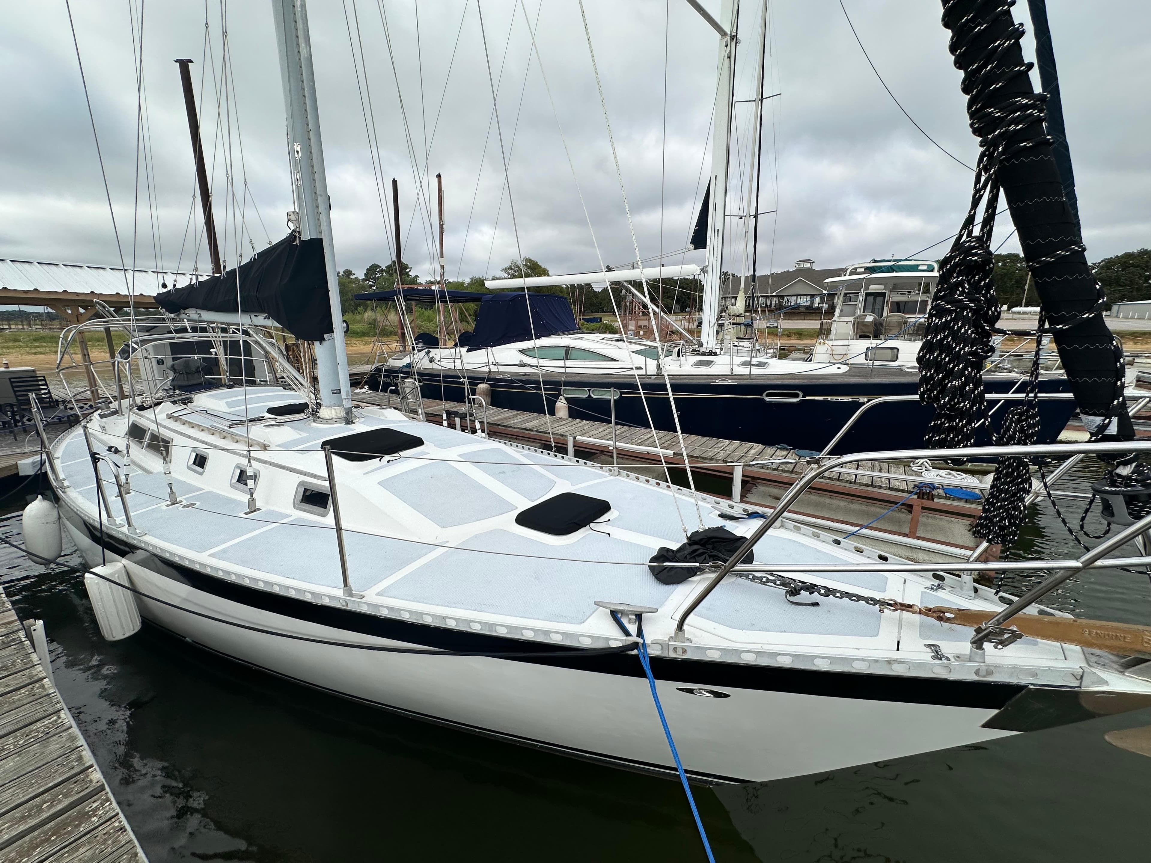 1979 Valiant 37 sailboat docked in marina, overcast sky.