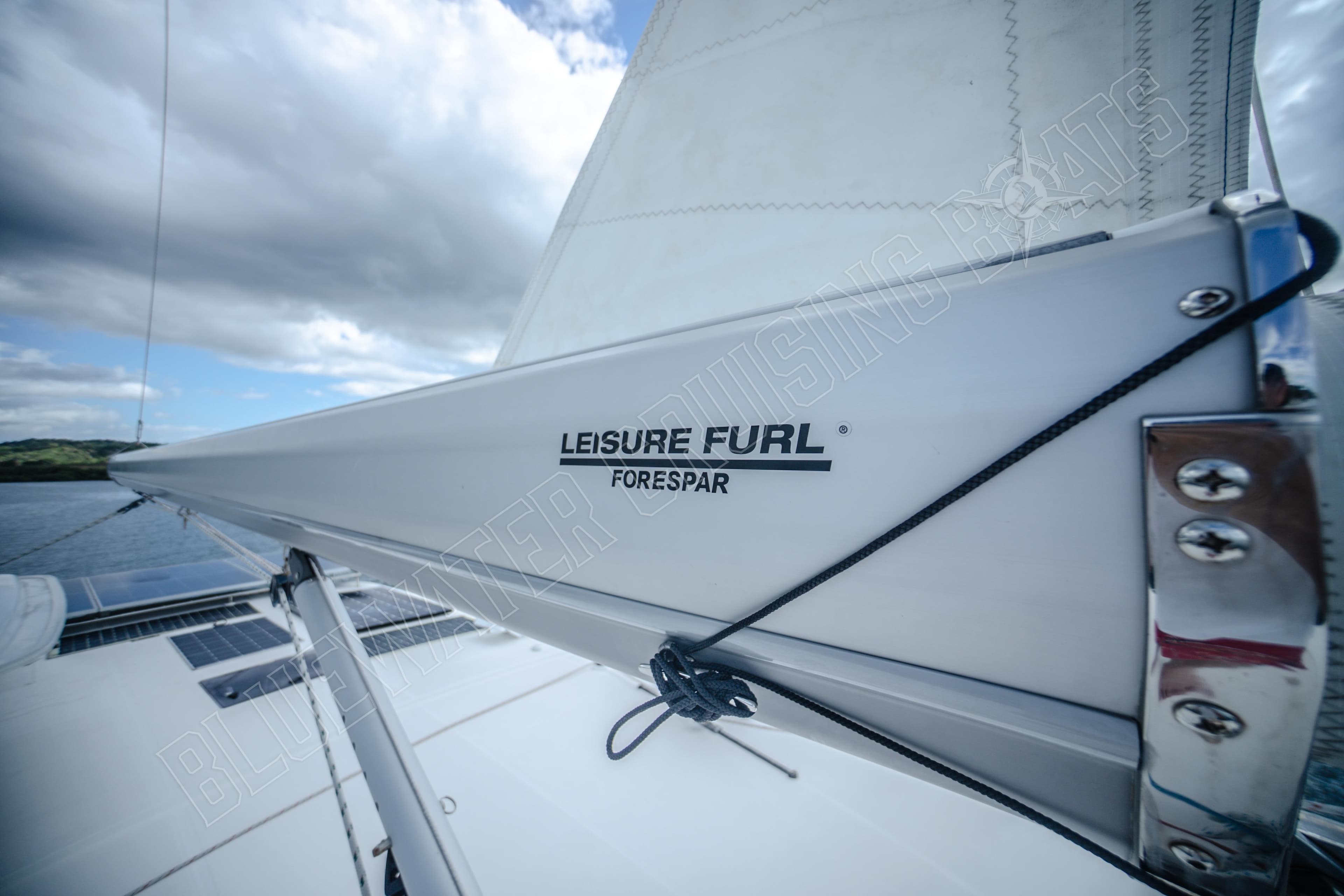 Sailboat boom with "Leisure Furl" branding, Leopard 48 model, 2015, under cloudy sky.