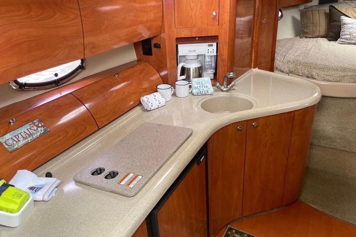 Interior of 2007 Larson Cabrio 350 yacht with kitchenette and cozy sleeping area.