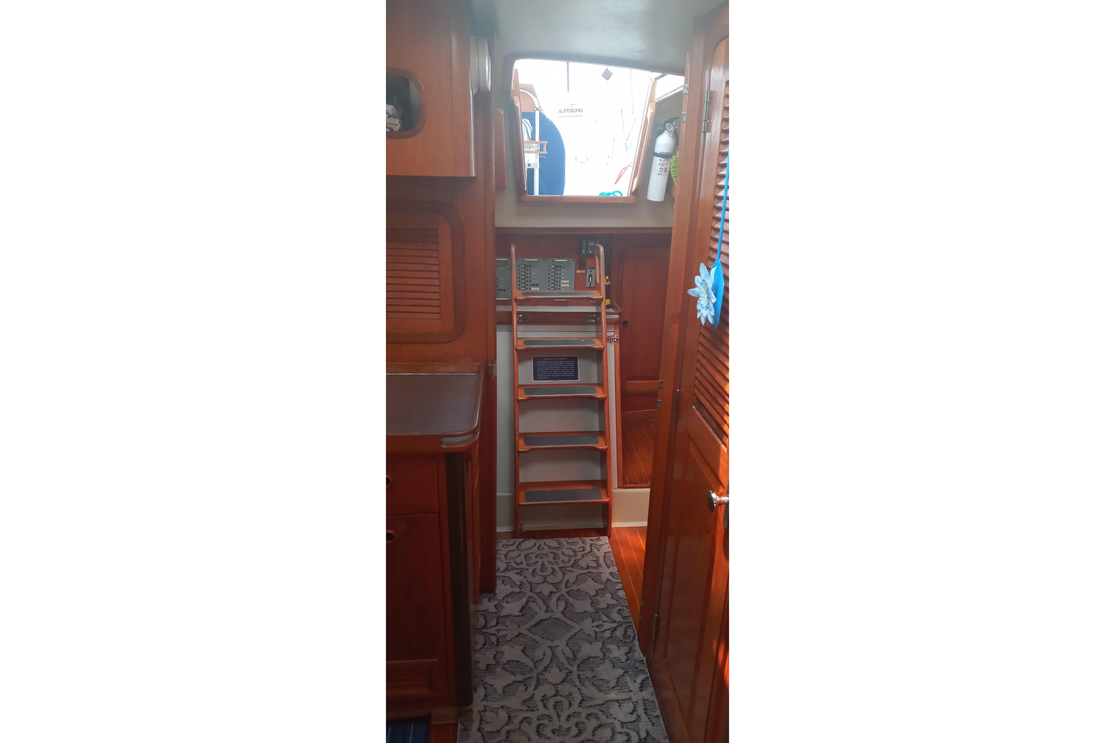 Interior of 1982 C&C Landfall 35 sailboat with wooden cabinetry and ladder.