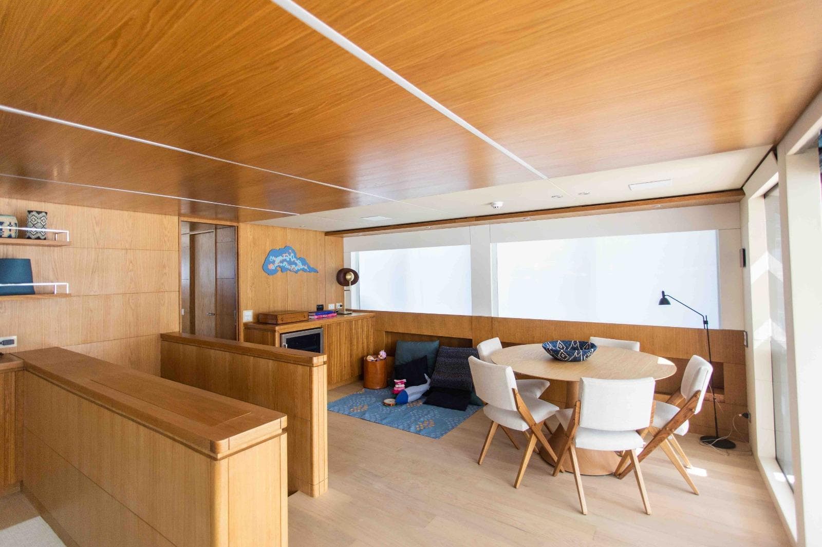 Luxurious interior of 2027 Inace Explora 90 yacht with modern dining area and wooden finishes.