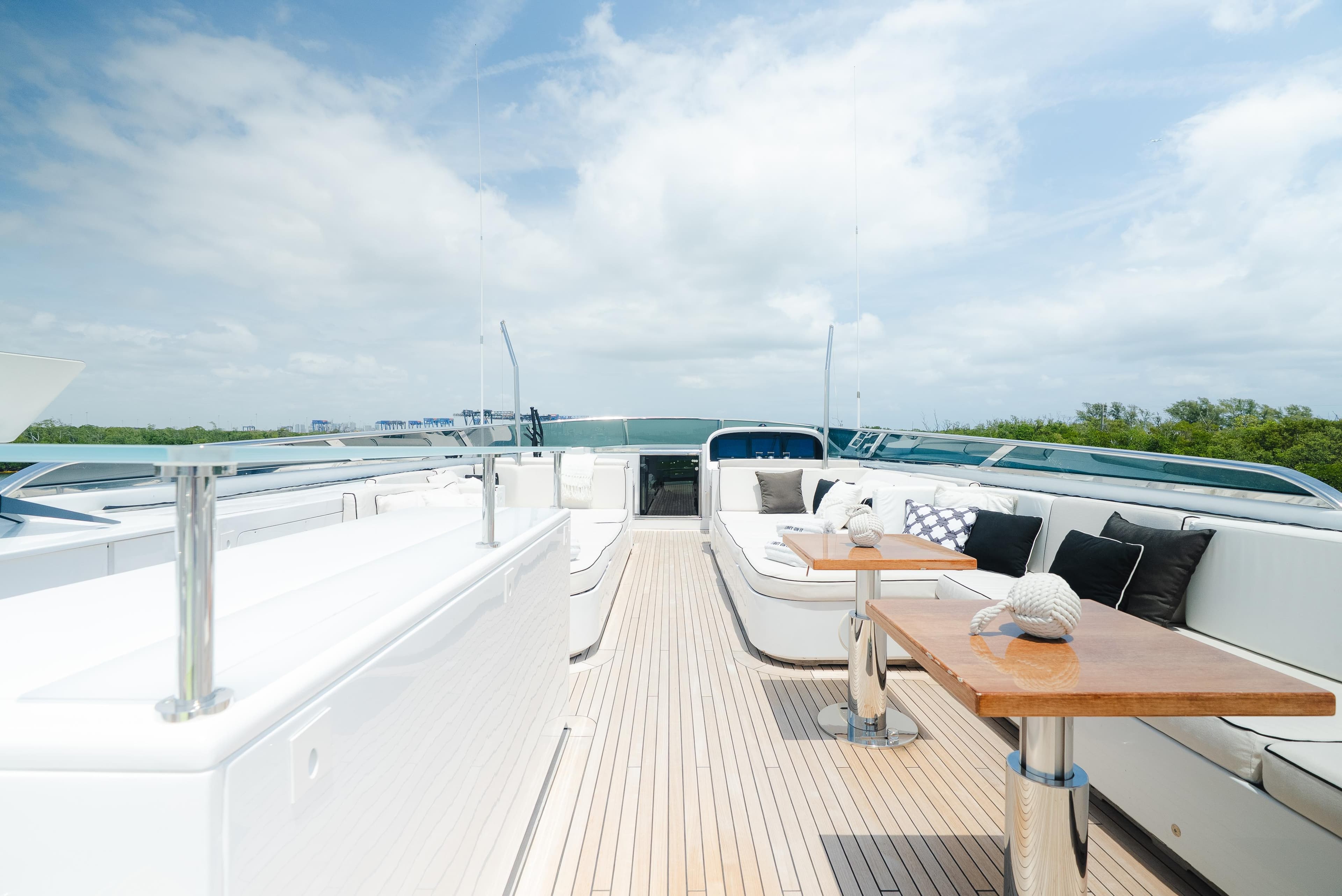 Luxurious Arno Leopard 46 yacht deck with elegant seating, wooden tables, and scenic views.
