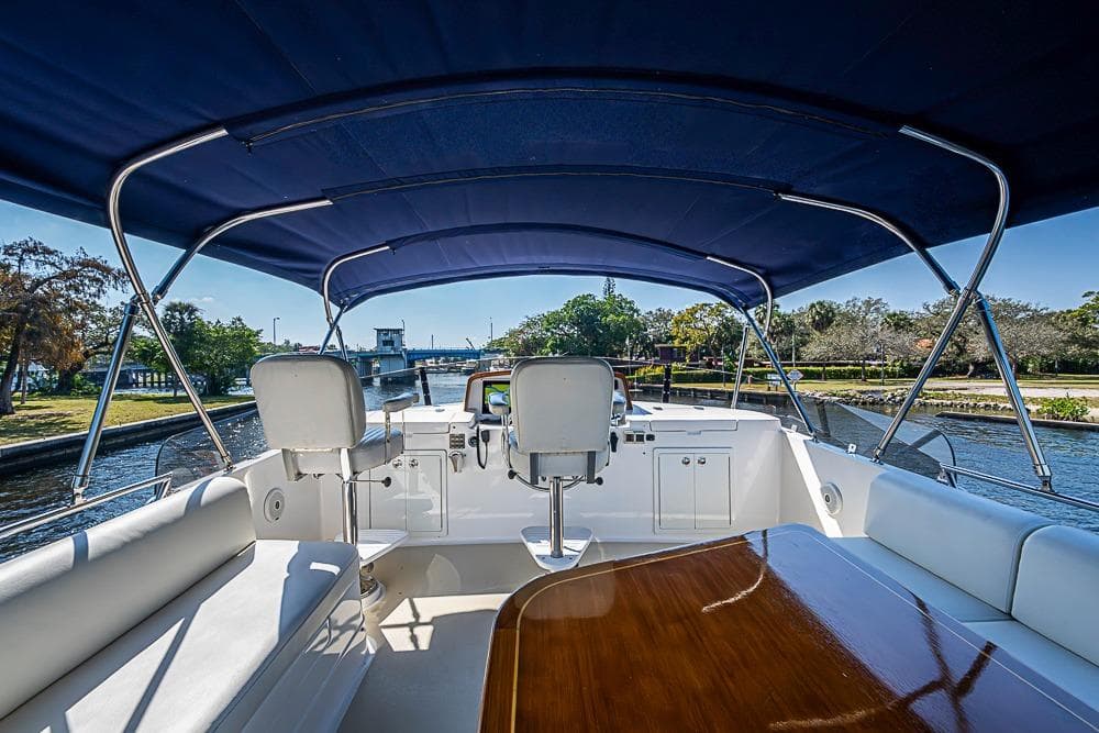 2013 Grand Banks 43 Europa yacht interior with blue canopy and scenic waterway view.