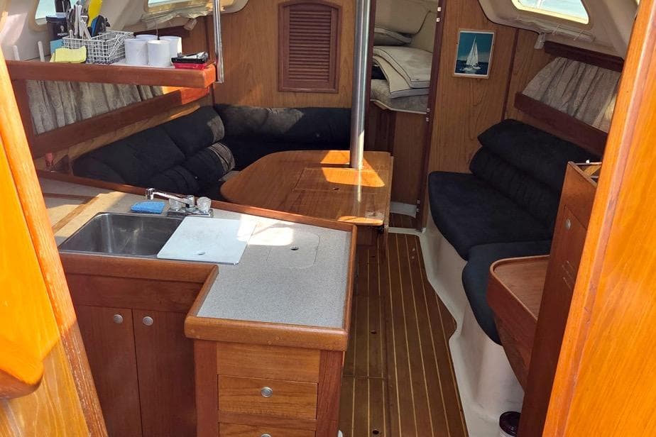 Interior of a 2001 Hunter 340 sailboat with wood finish and cozy seating area.
