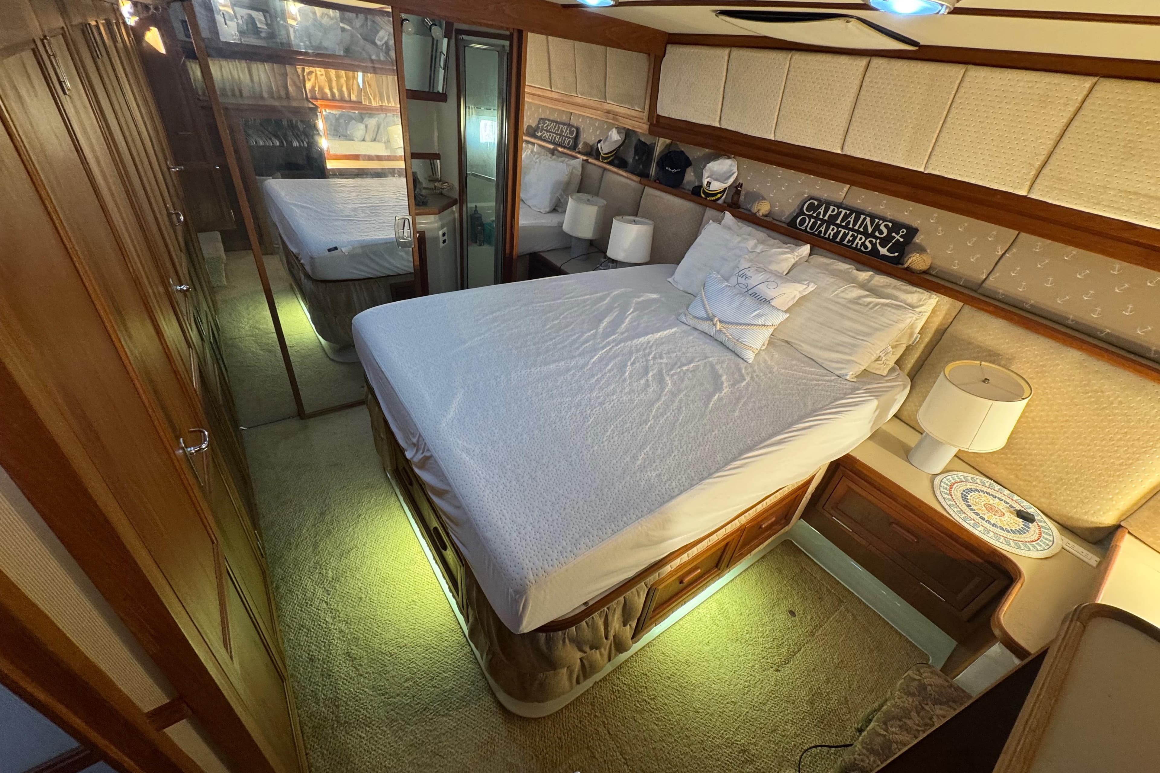 1986 Carver 42 Aft Cabin Motor Yacht bedroom with cozy decor and mirrored closet.