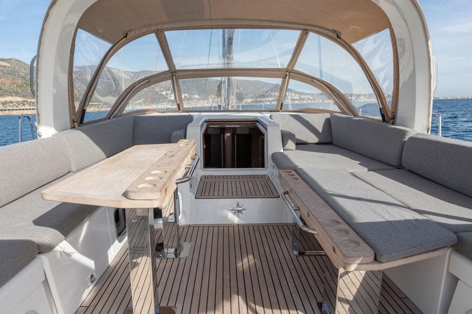 Luxurious 2023 Jeanneau 60 yacht interior with spacious seating and elegant wooden tables.