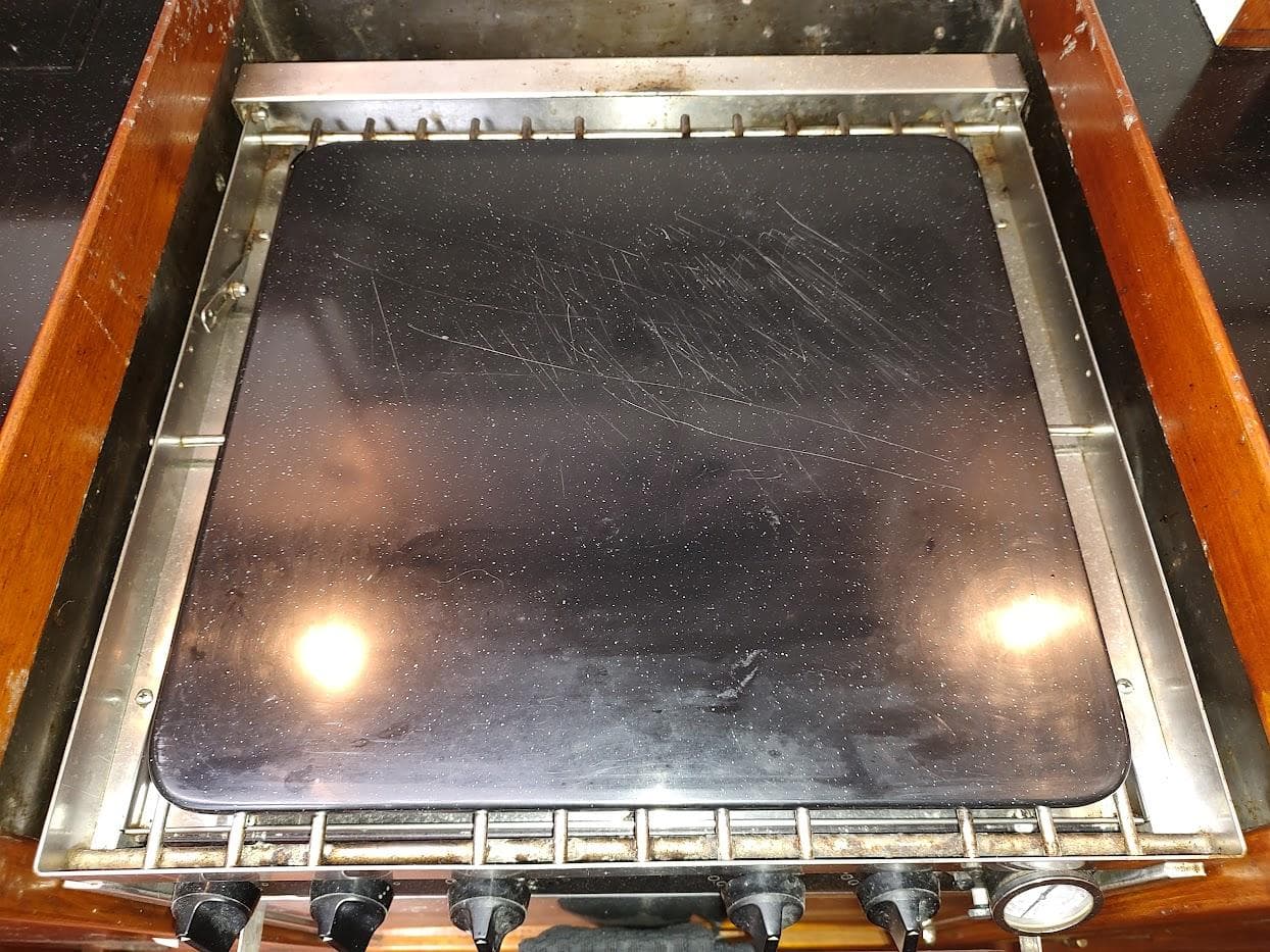Stove top on a 1997 Hylas 46 yacht, featuring a black cover and control knobs.