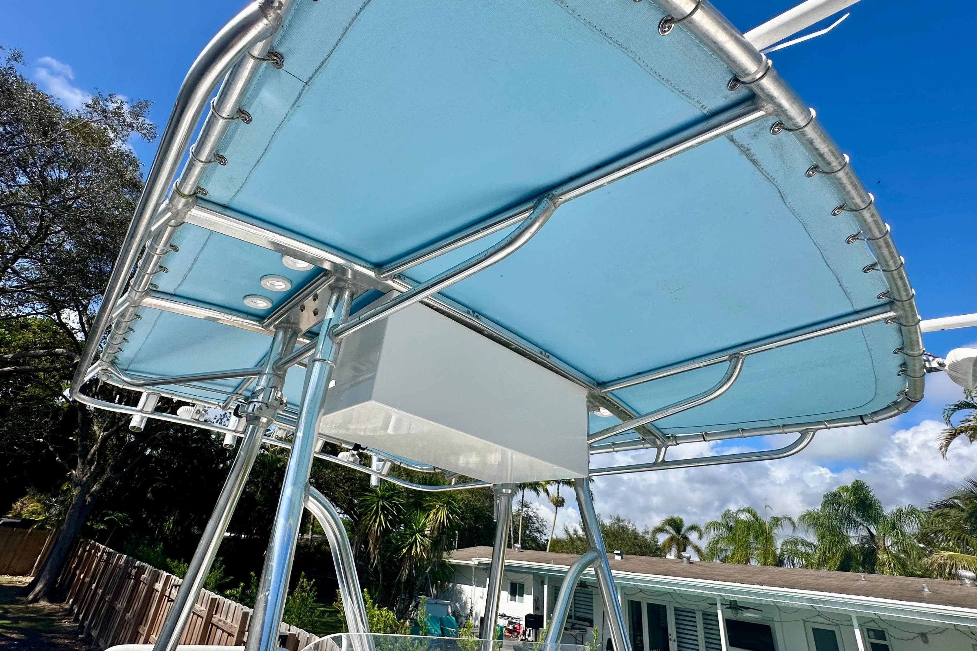 2001 Contender 23 Open boat T-top with blue canvas under clear sky.