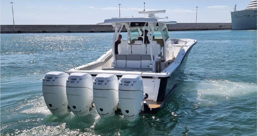2017 Scout 420 LXF boat with four engines cruising in a harbor.
