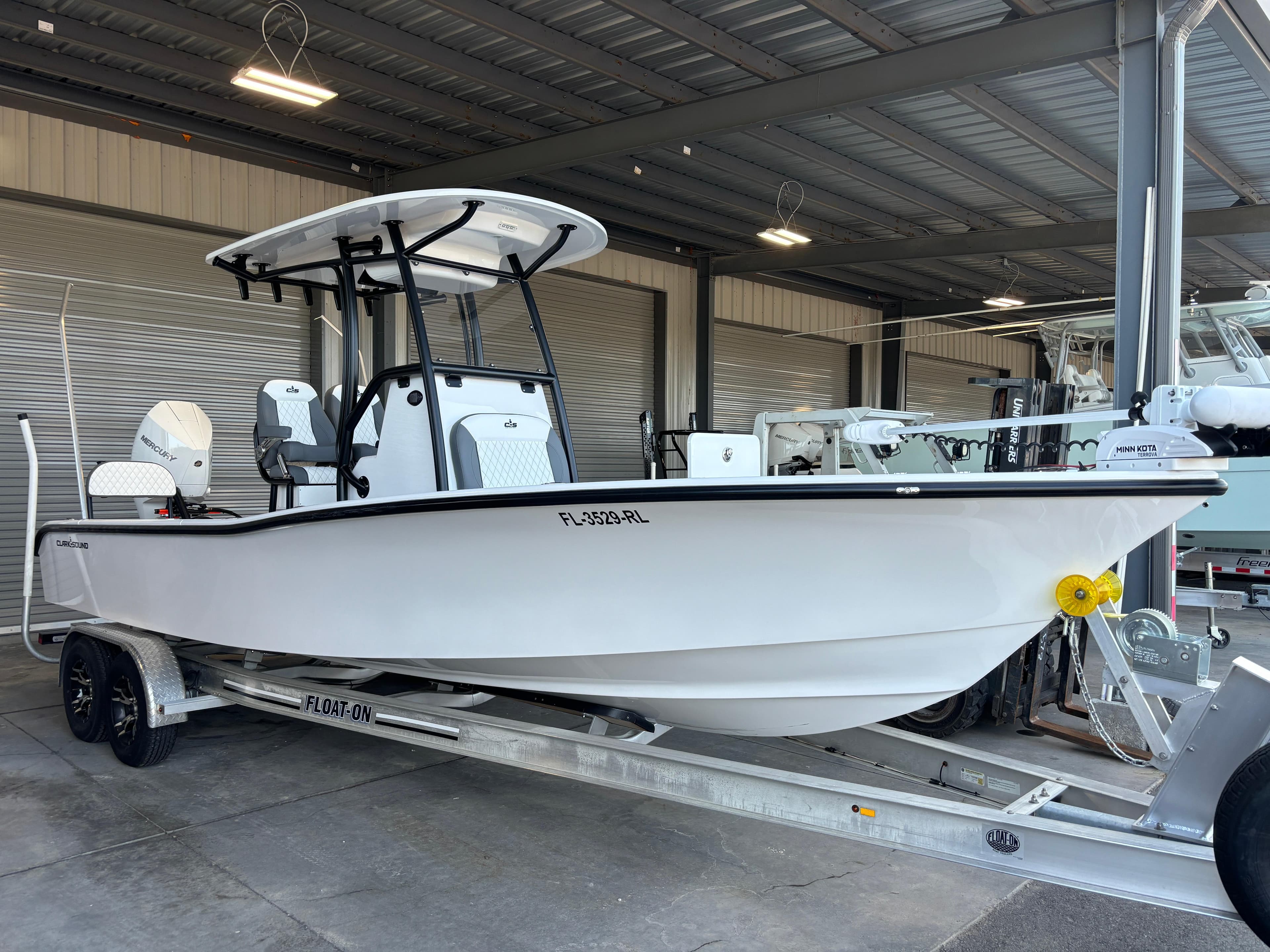 2025 Clark Sound 24 boat on trailer in covered storage area.