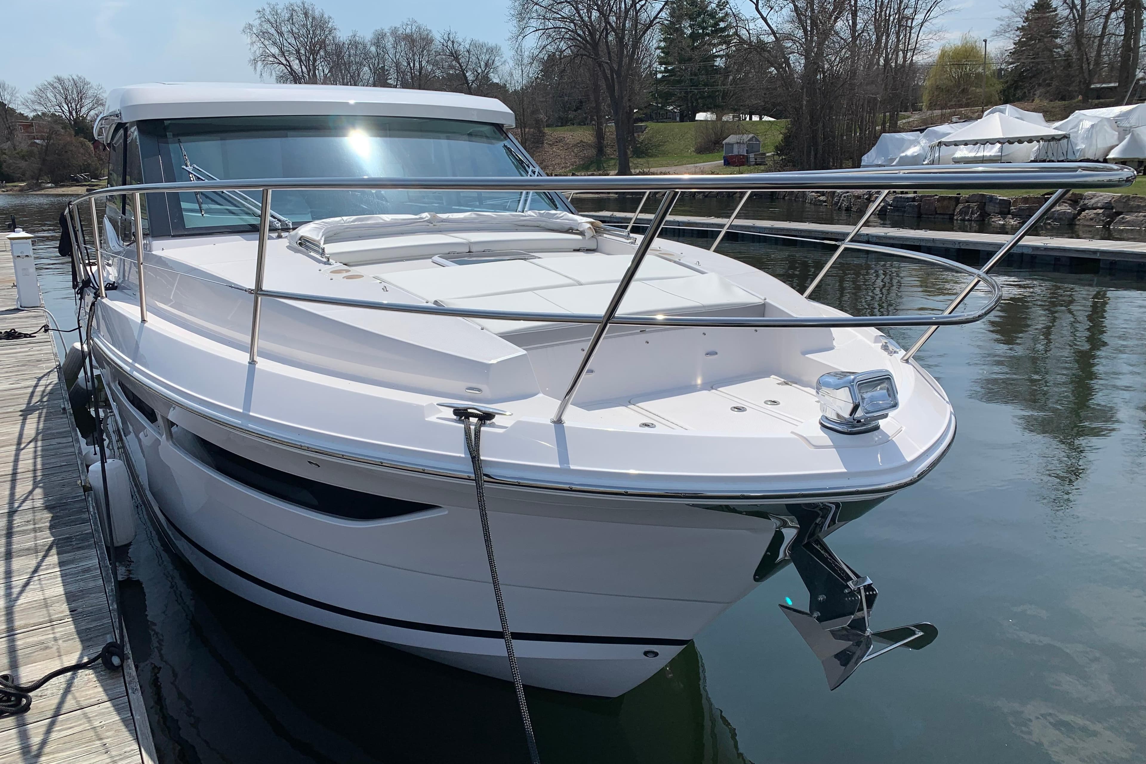 2025 Regal 38 Grande Coupe yacht docked on a calm waterway.