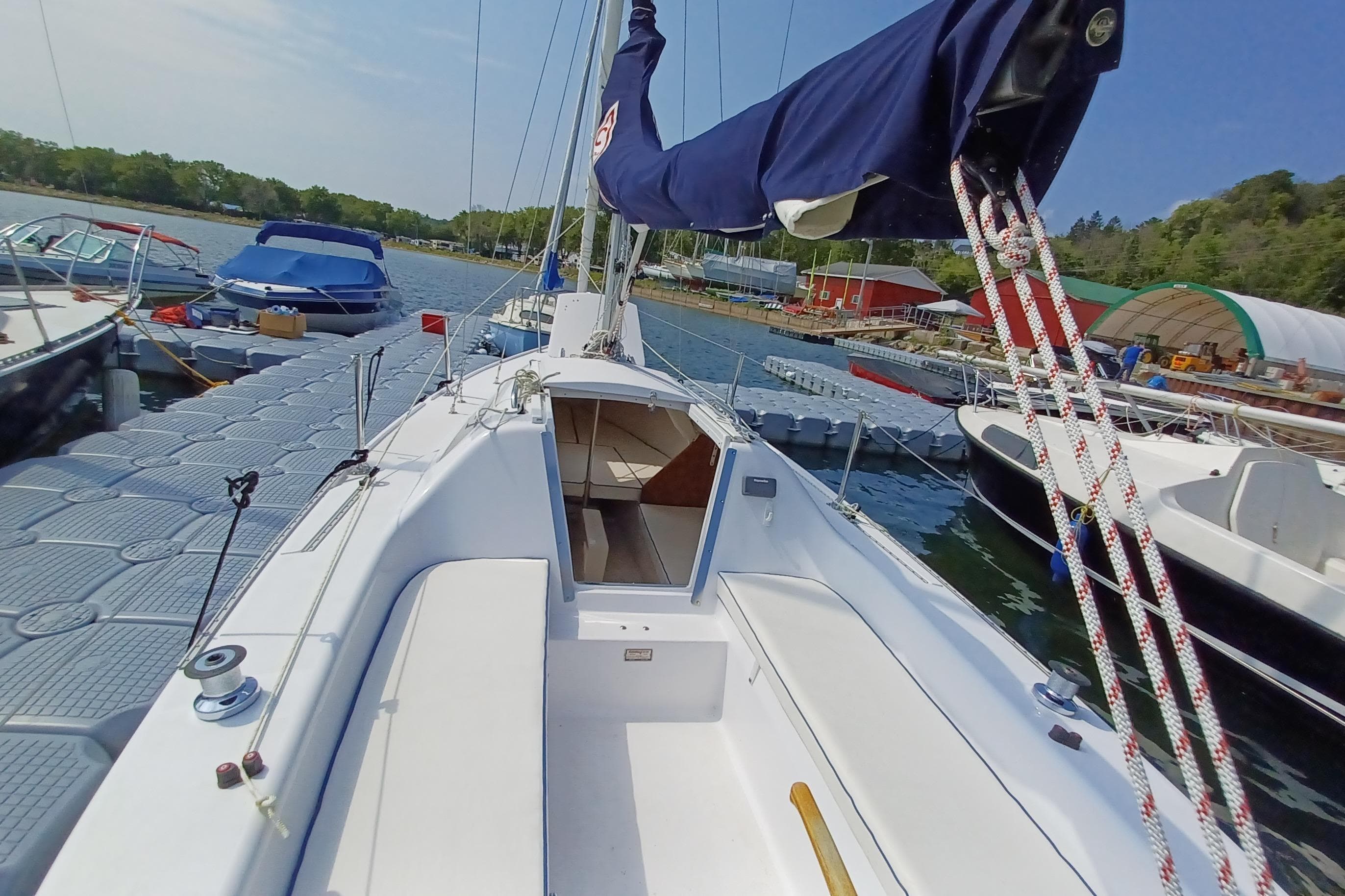 2023 Catalina 22 Sport sailboat docked at marina, featuring spacious cockpit and sleek design.