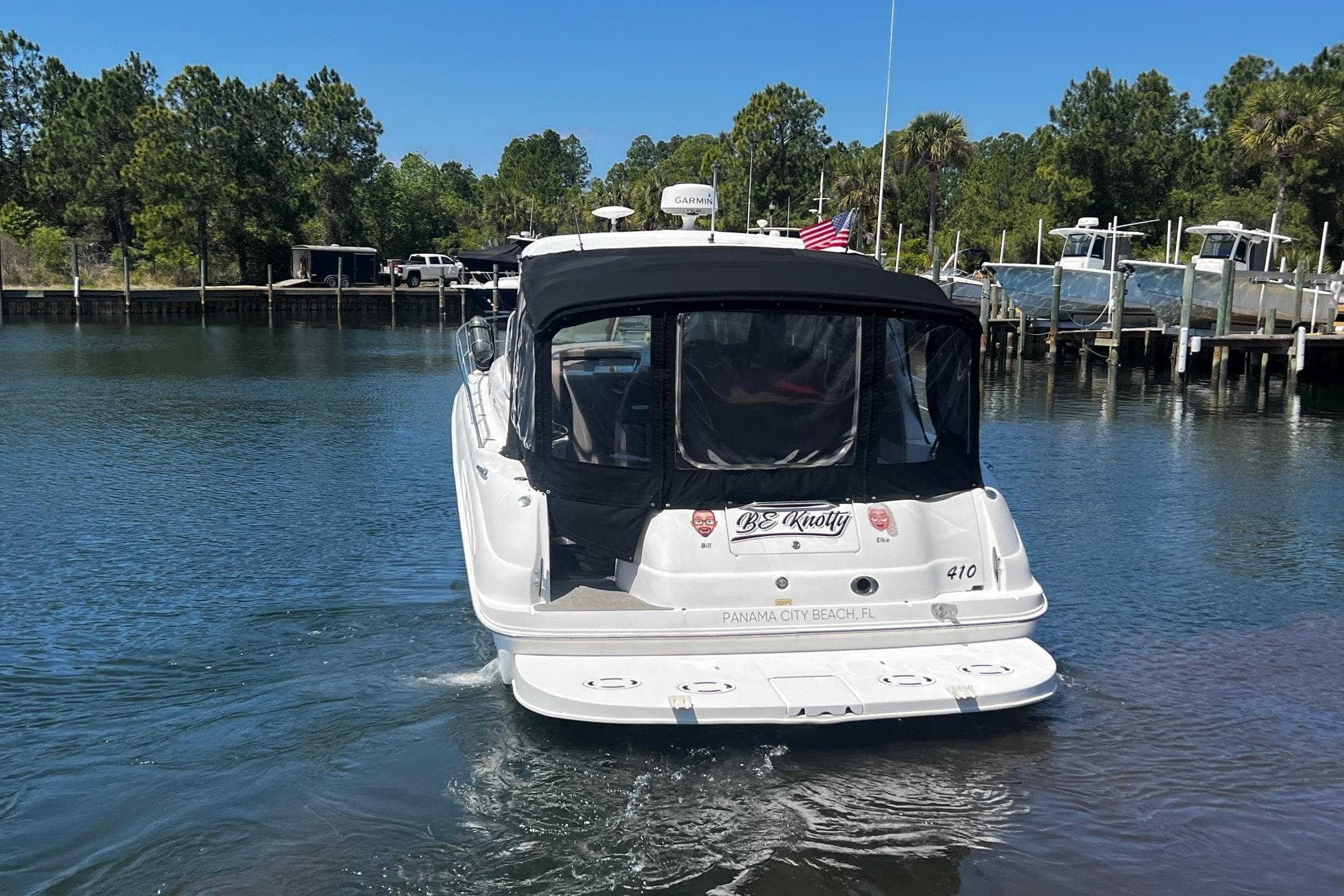 2003 Sea Ray 410 Express Cruiser docked in a serene marina setting.