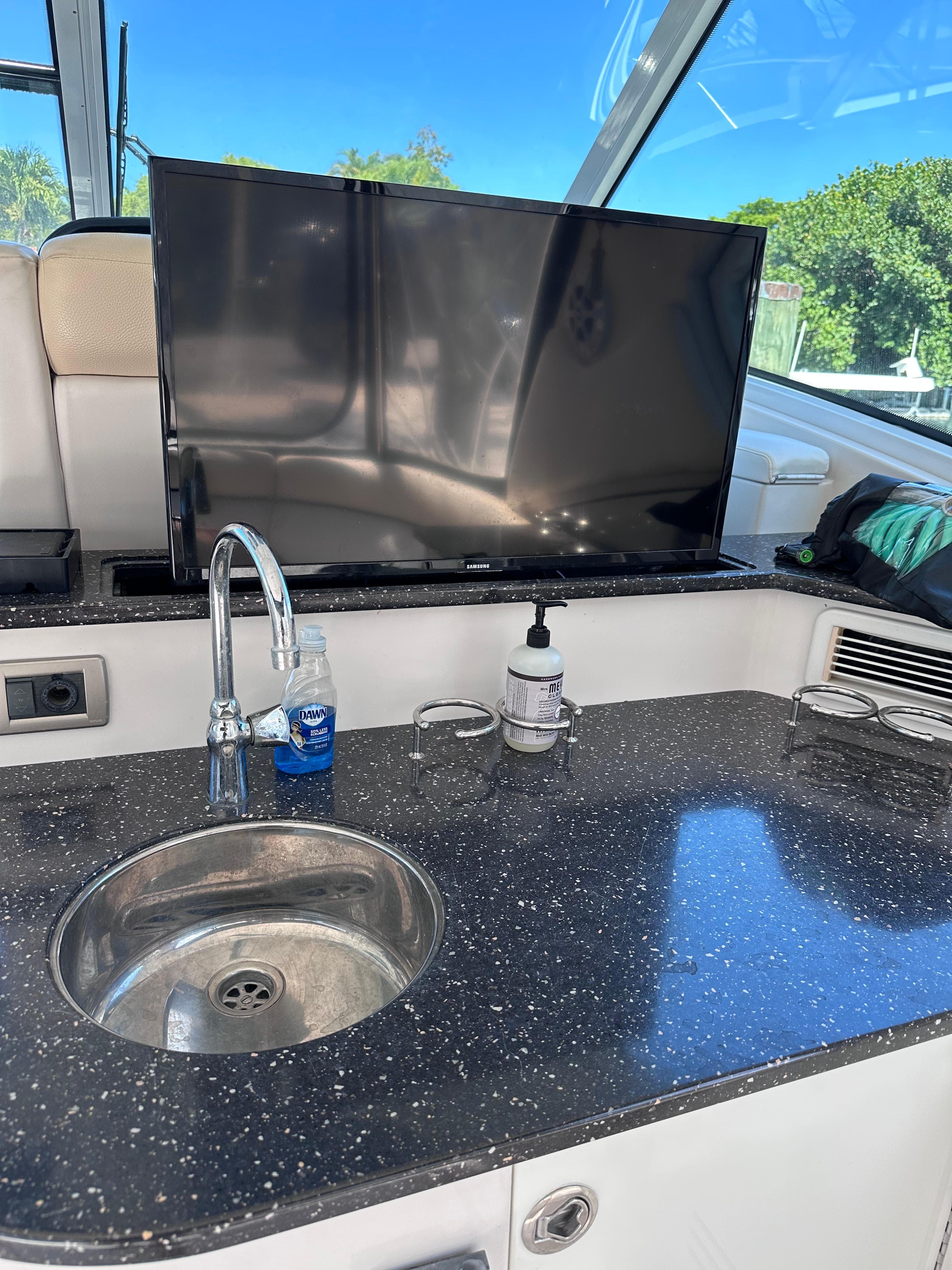 Luxury yacht interior with sink, countertop, and TV on a 2008 Four Winns V458.