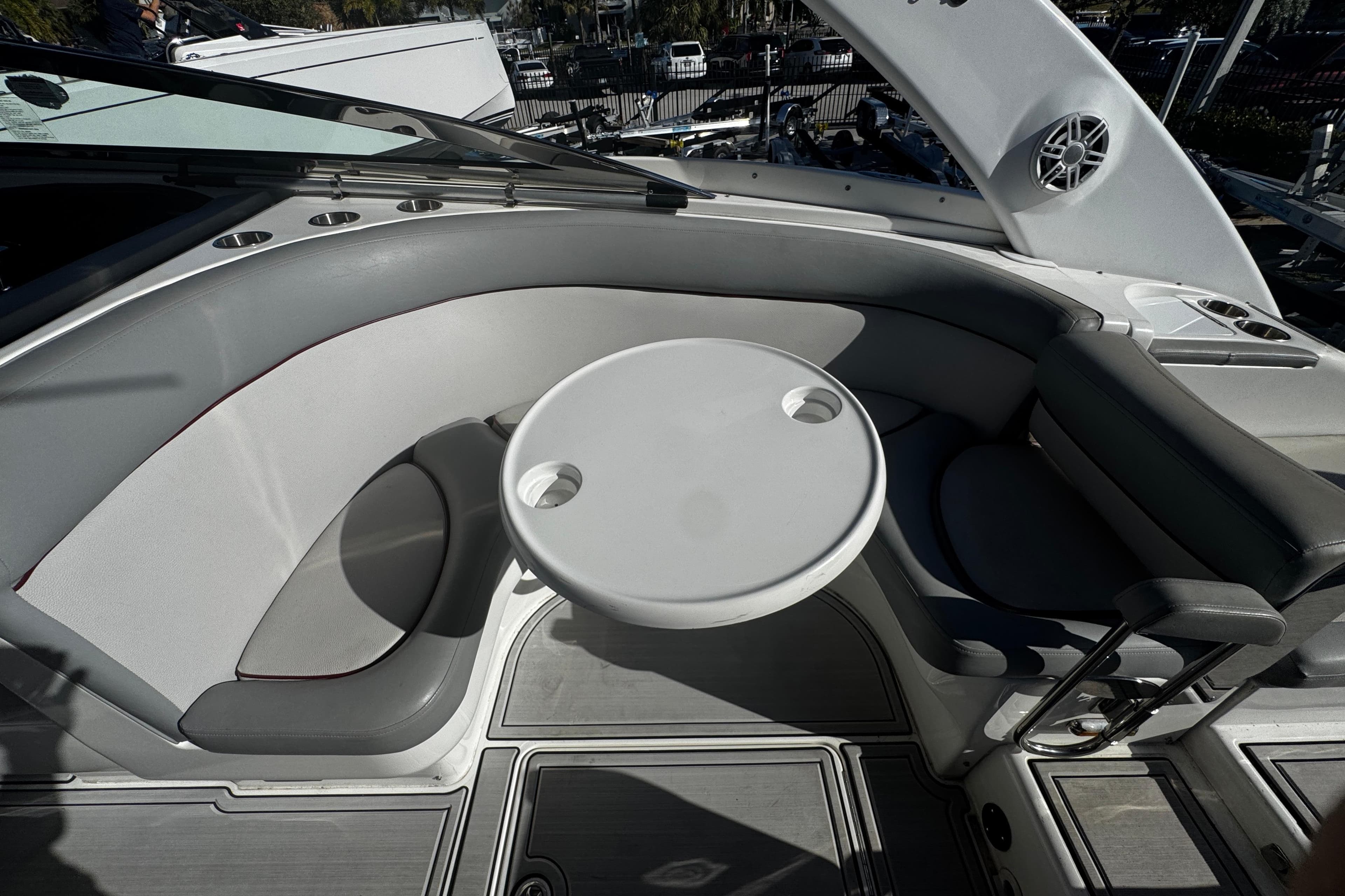 Luxury seating area on a 2005 Cobolt 36 boat with round table and cup holders.