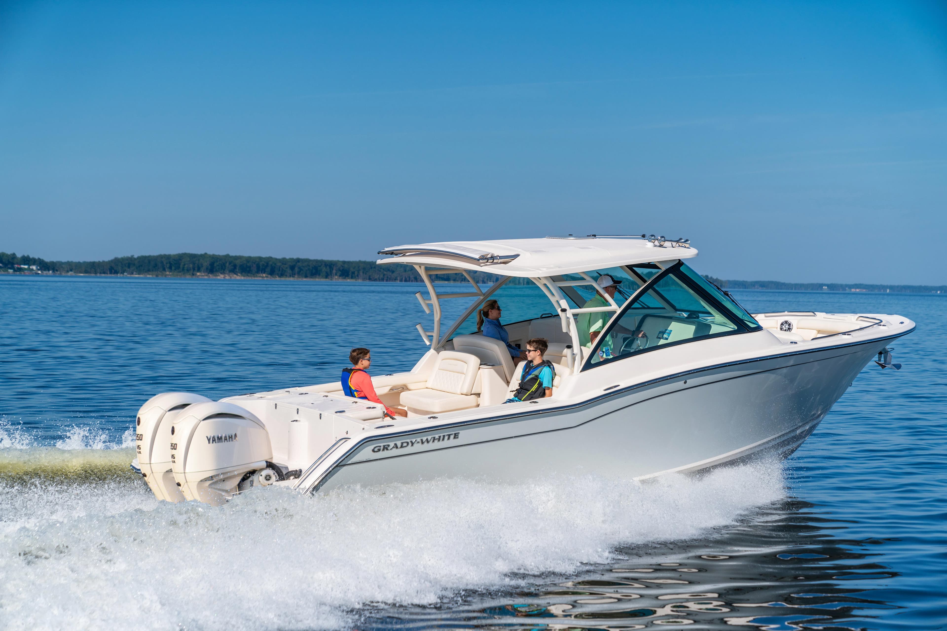 2025 Grady-White Freedom 325 boat cruising on open water, clear blue sky.