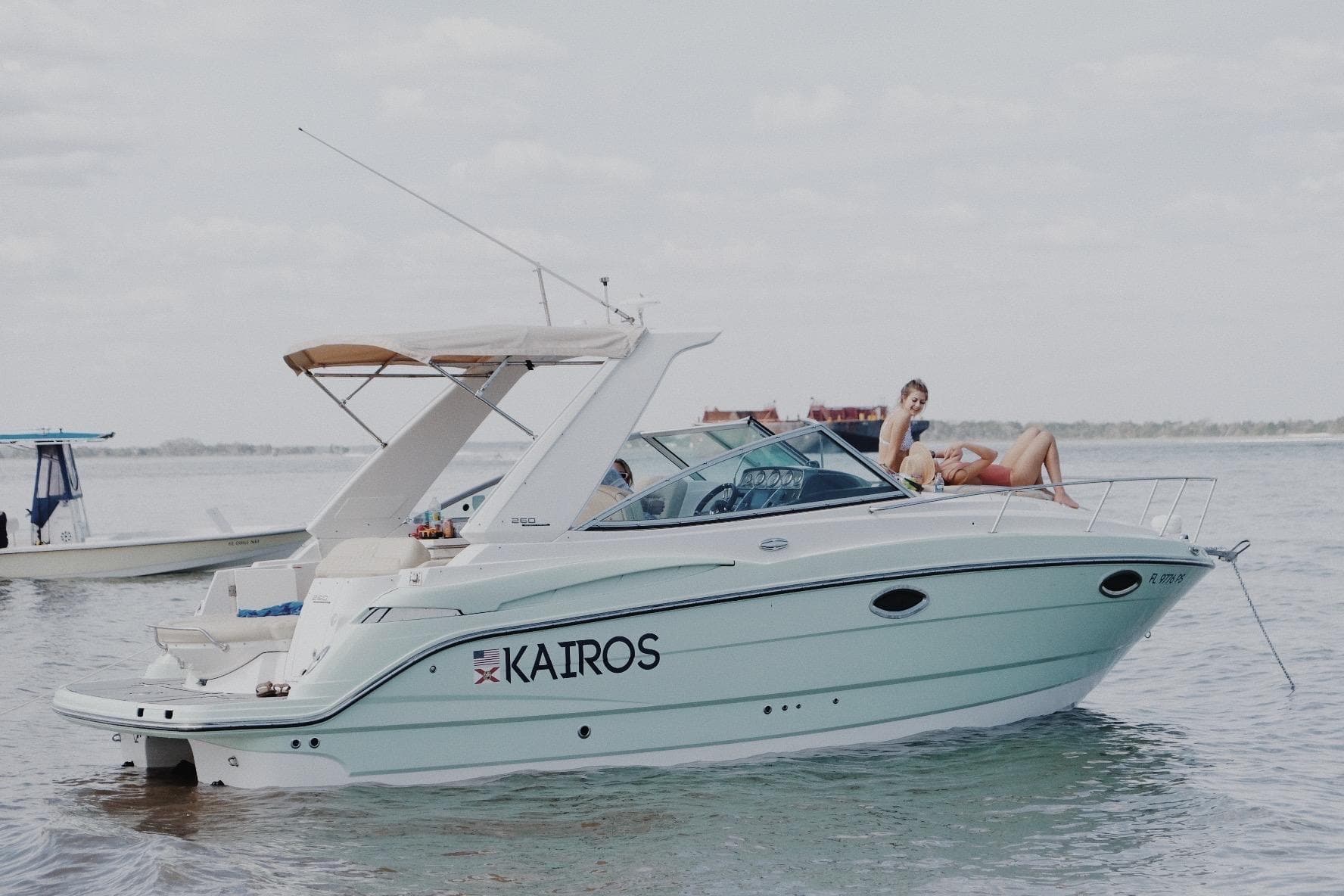 2014 Monterey 260 Sport Yacht "Kairos" on water with people relaxing onboard.