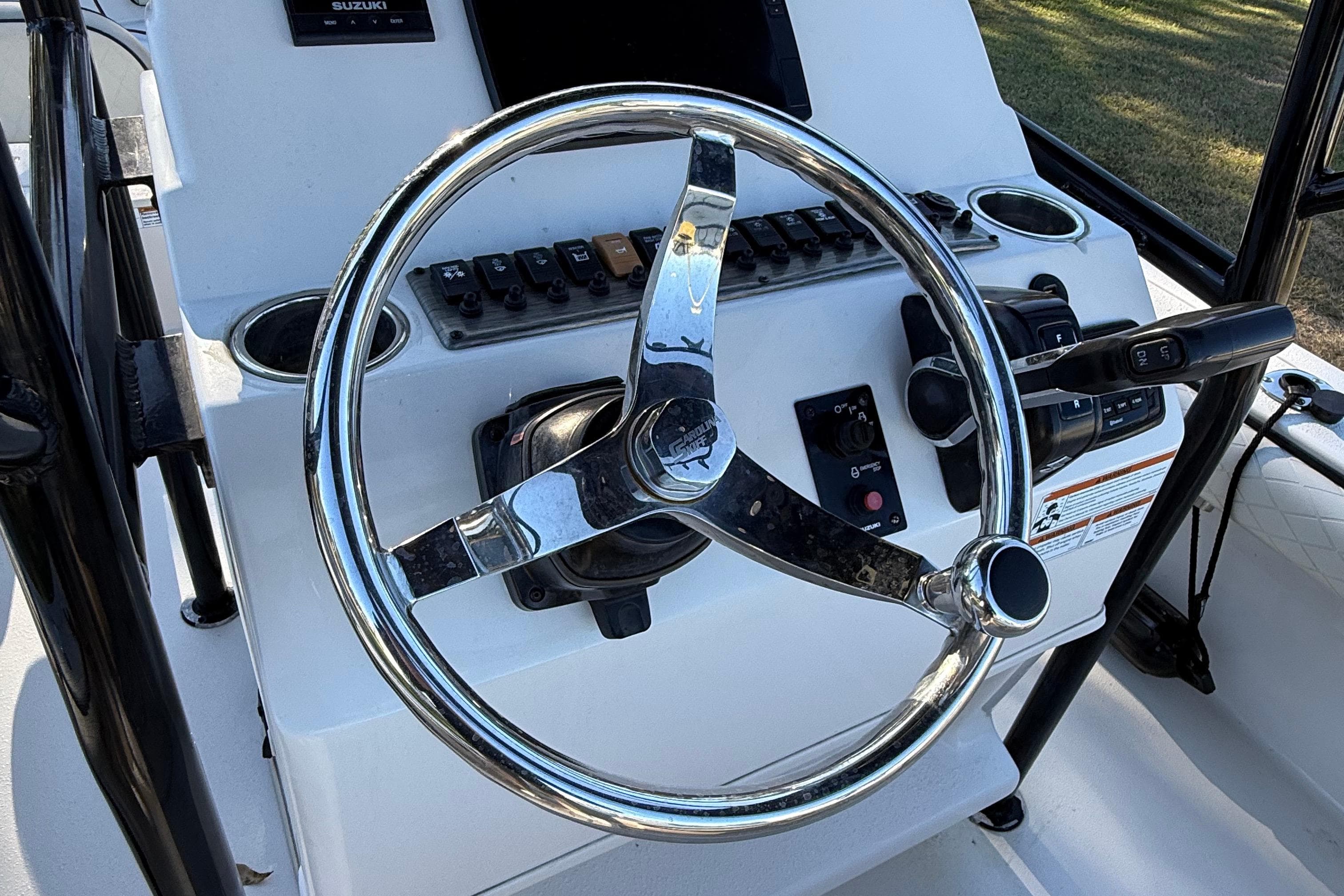 Steering console of 2021 Carolina Skiff 26 Ultra Elite boat with controls and switches.