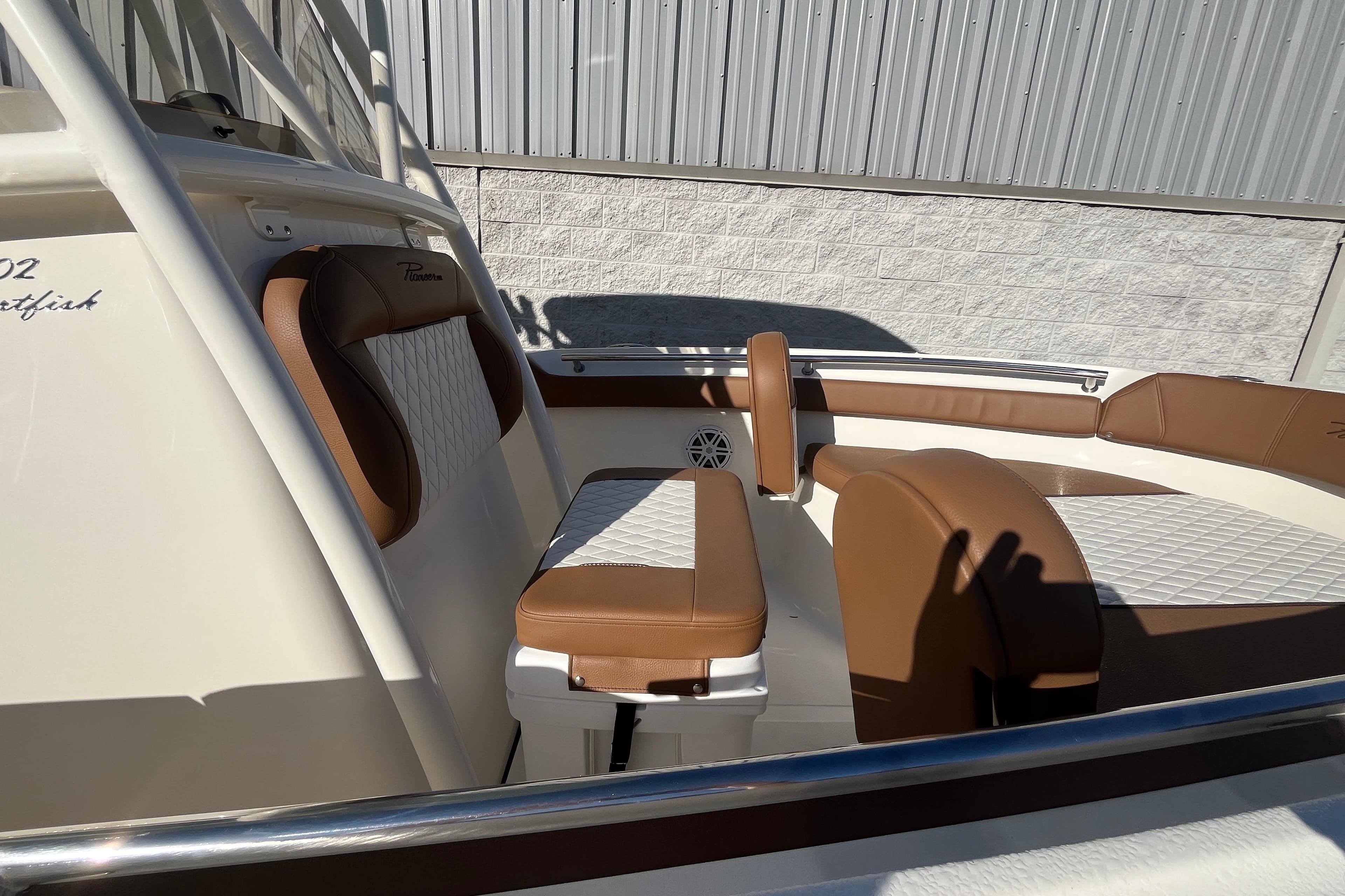 2026 Pioneer 202 Sportfish boat interior with brown and white cushioned seating.
