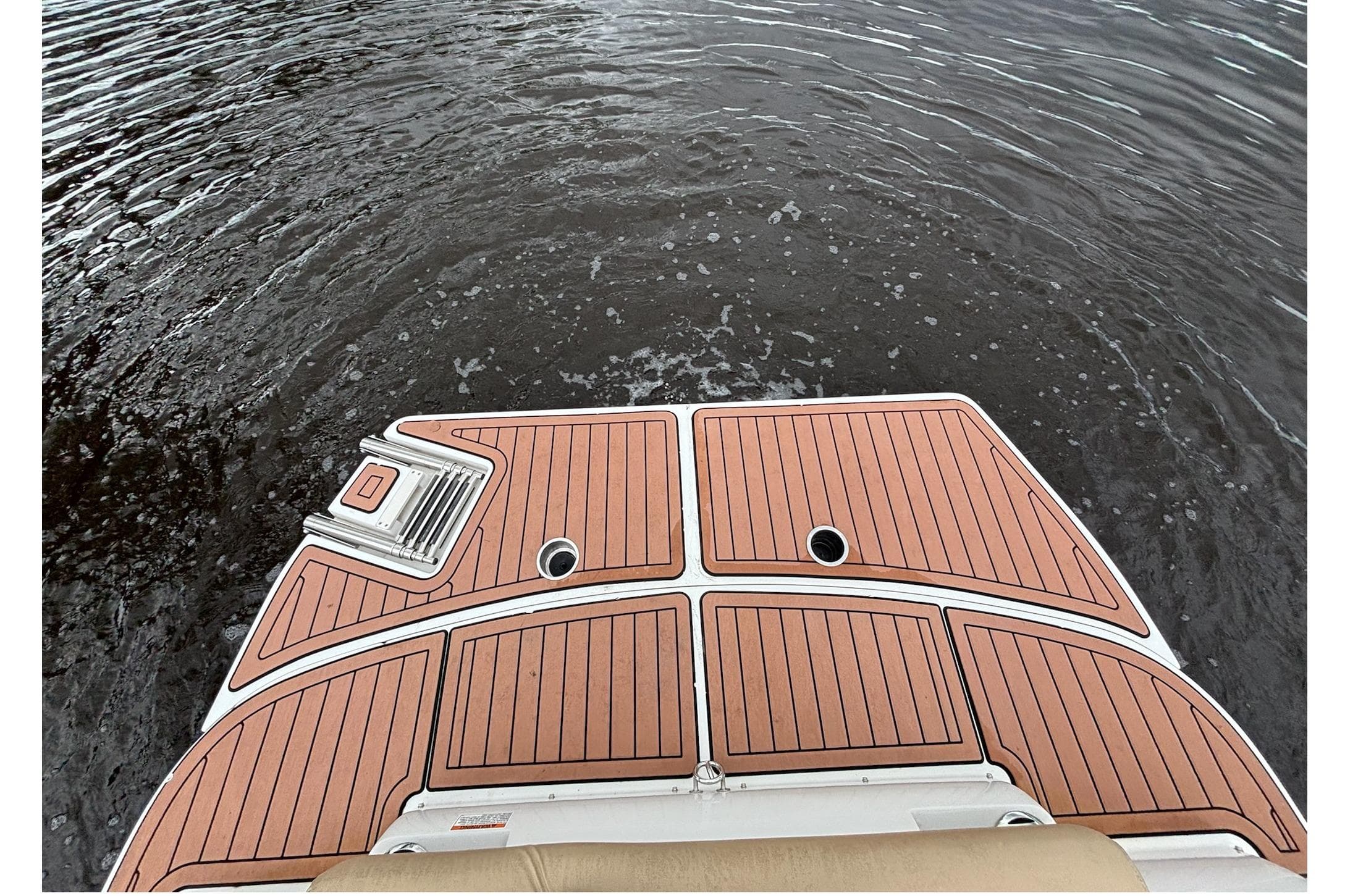 2017 Starcraft Star Step 221 I/O boat deck with wood finish on water.
