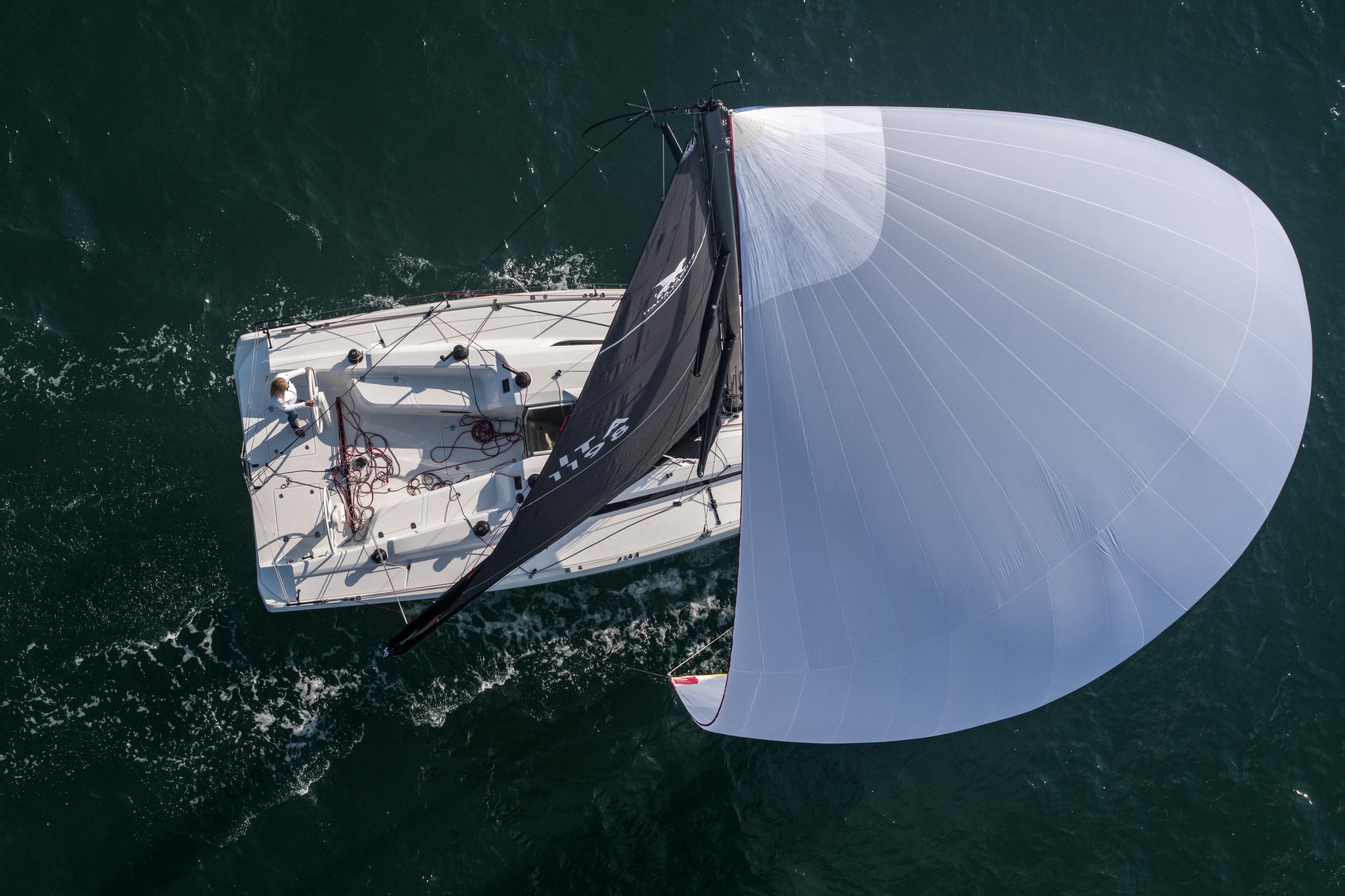 Aerial view of 2026 Italia Yachts 11.98 sailing with full spinnaker on open water.