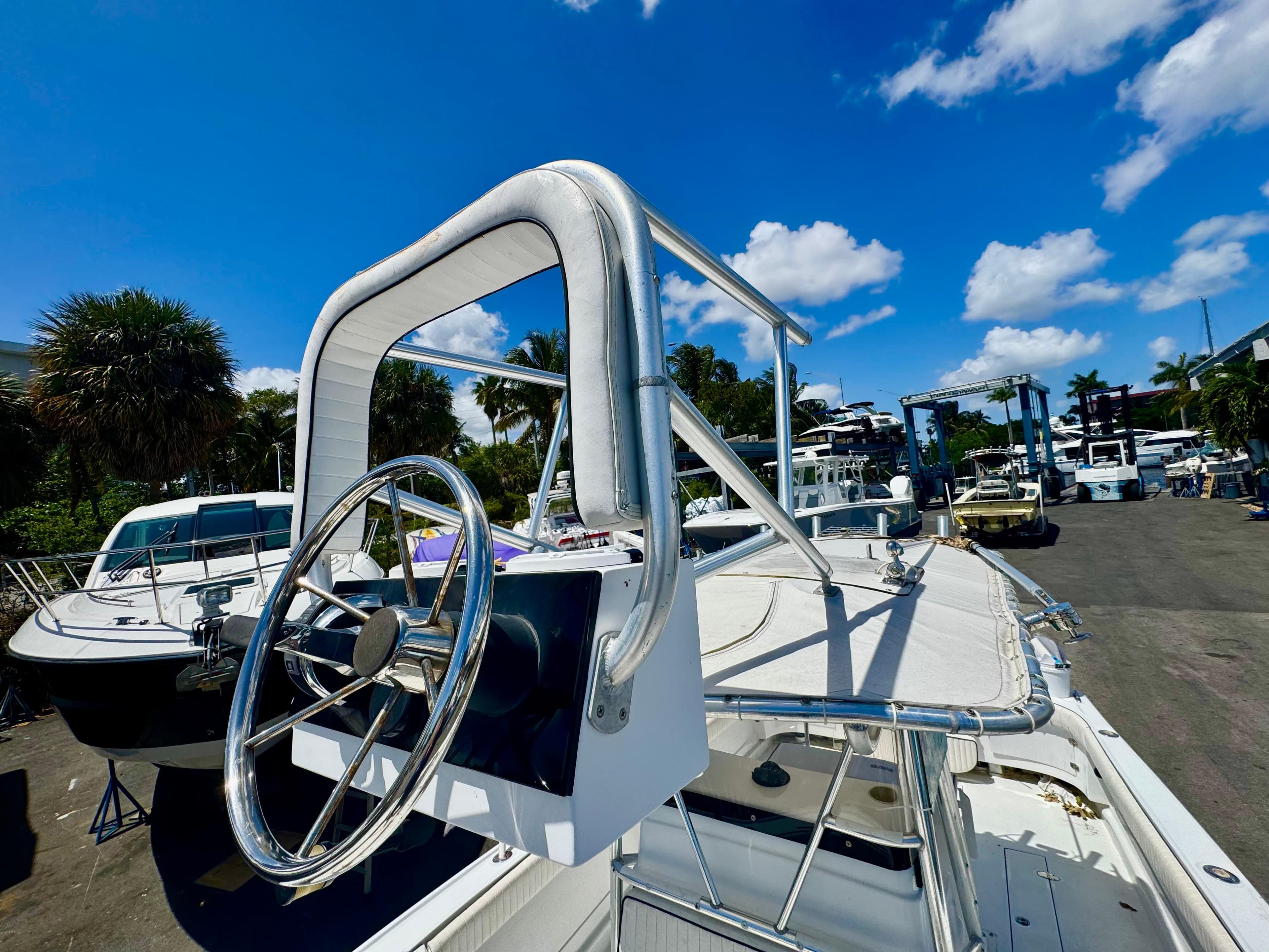 1963 Bertram 25 Mark II convertible sport cruiser with steering wheel, docked under blue sky.